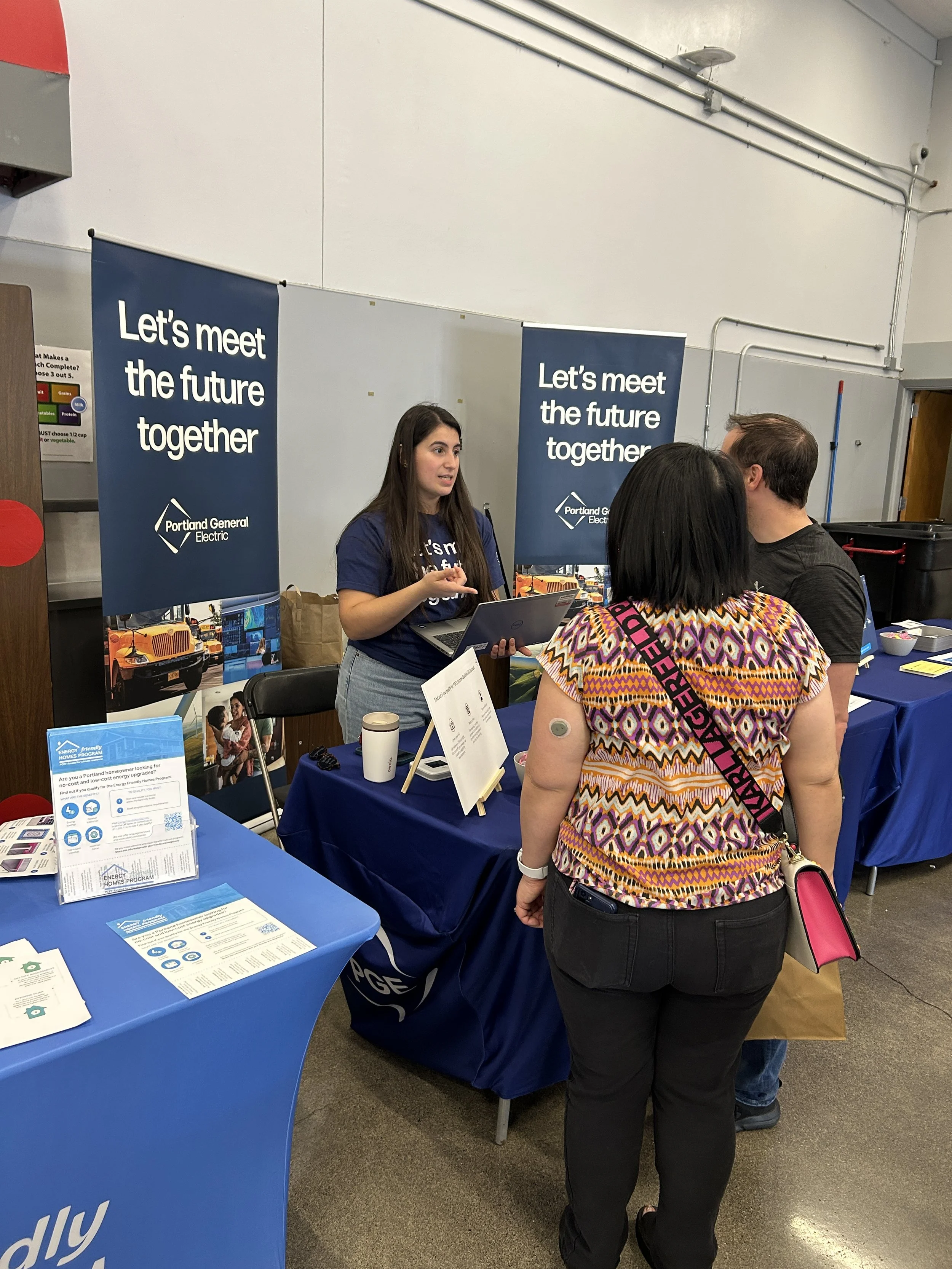  A community member engaging with Portland General Electric sponsor representatives at a CSN community resource fair in Portland, Oregon. 