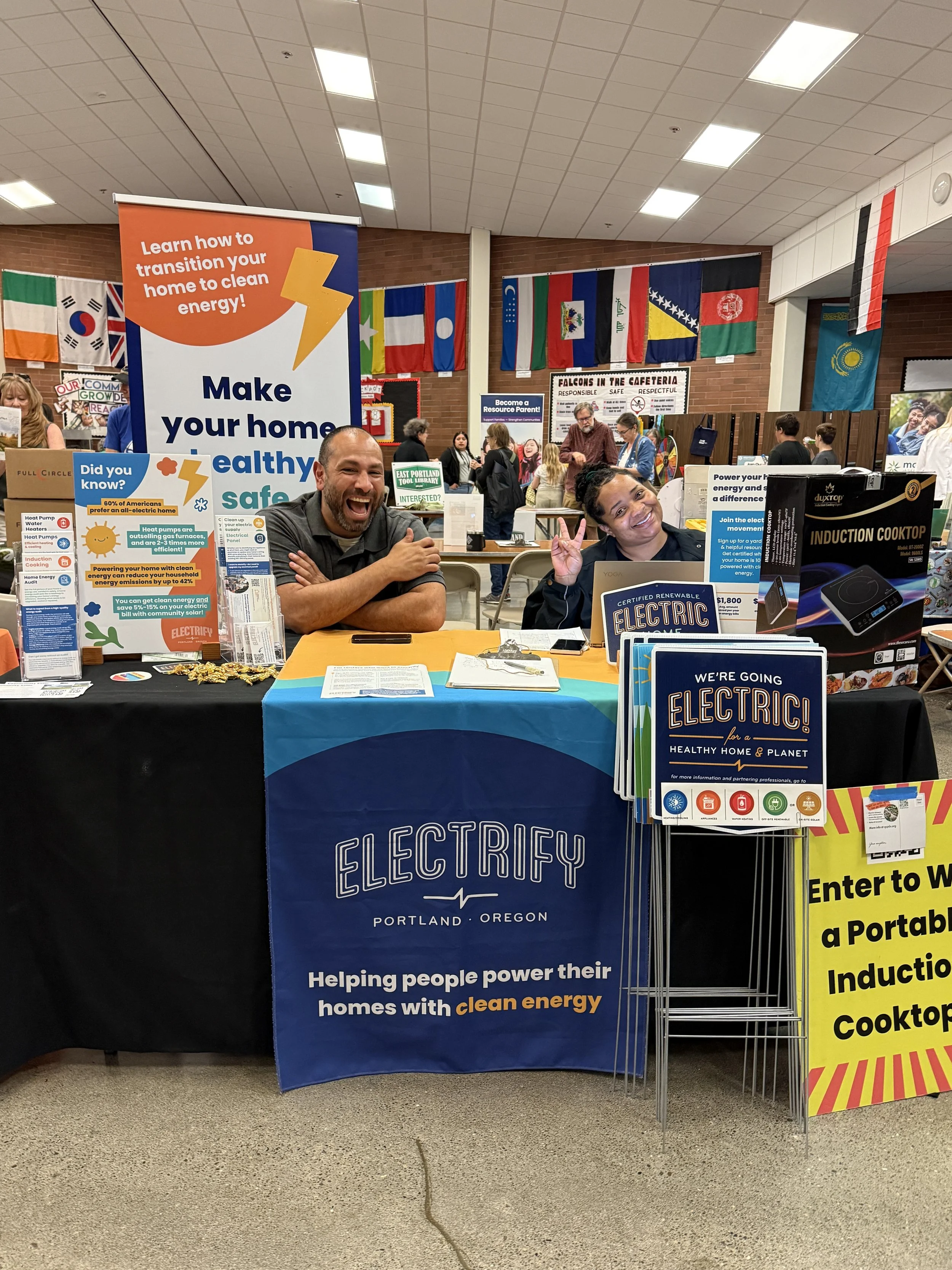 Man and woman at Electrify PDX table at Community Resource Fair