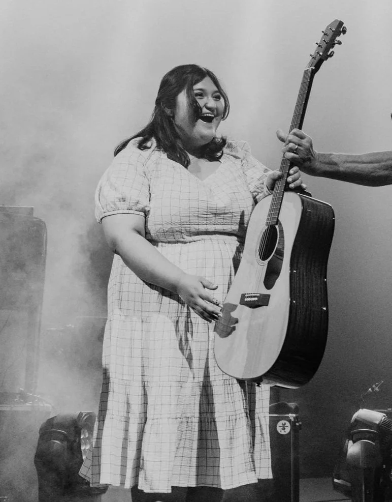 Girl receiving guitar at show