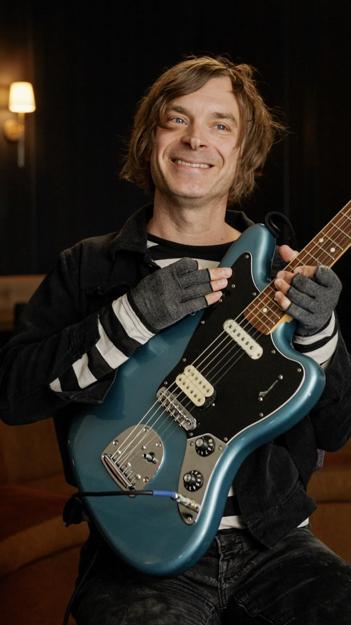 Musician Ryan Smith holding guitar and supporting Free Guitars 4 Kids