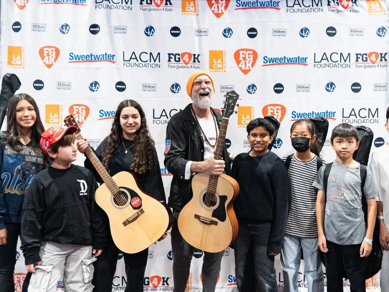 Brent Paschke hands guitars to kids at LACM guitar giveaway