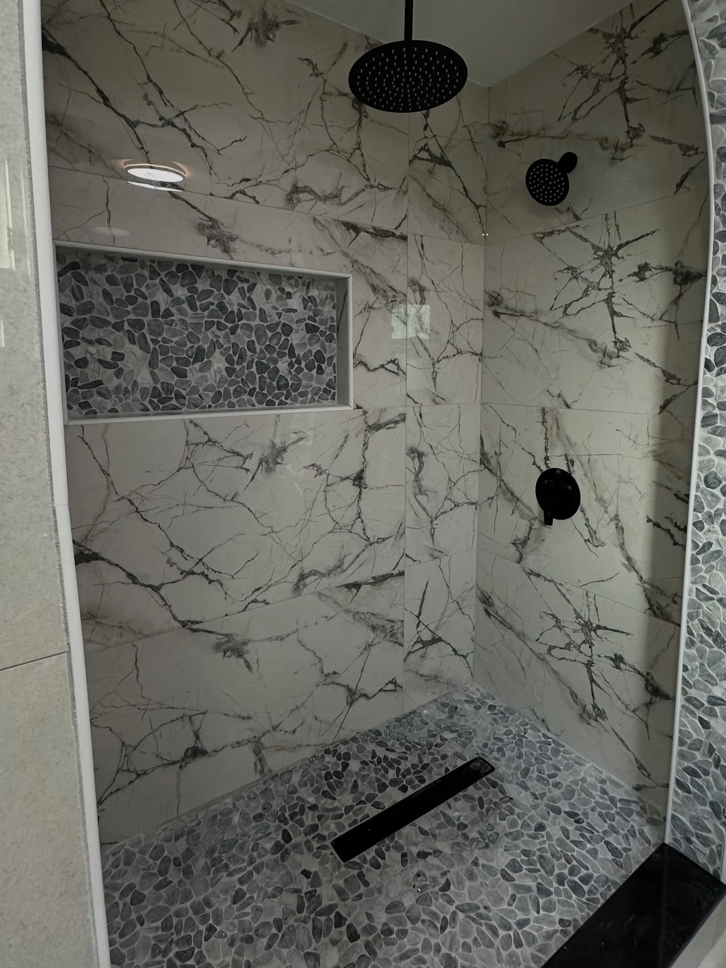 A serene marble sanctuary! 🛁✨ Rain showers, pebble accents, and that spa glow&mdash;pure bliss.

#HomeImprovements #HomeDecor #Home #Construction #HomeImprovement #HomeRenovation #Renovation #HenryDidIt #Commercial #Residential #Flooring #BathroomRe