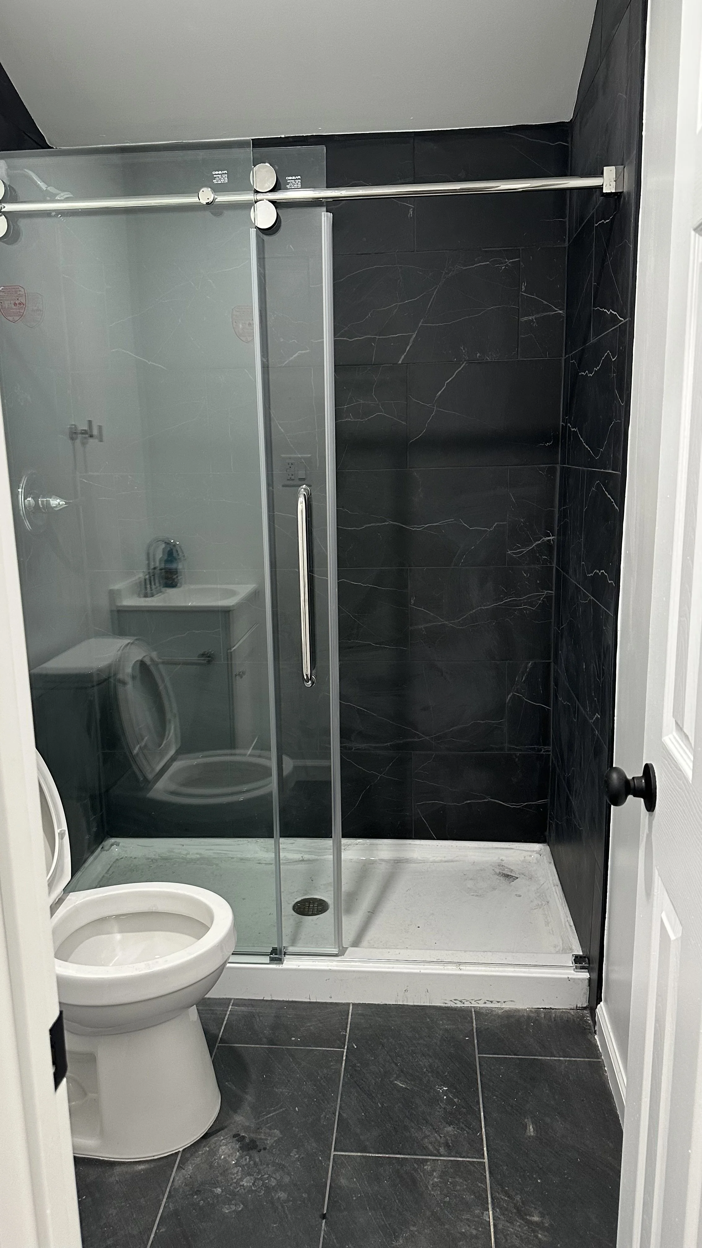 Demolition, tile flooring, wall, light fixture, shower fixtures, toilet, vanity and door installation.