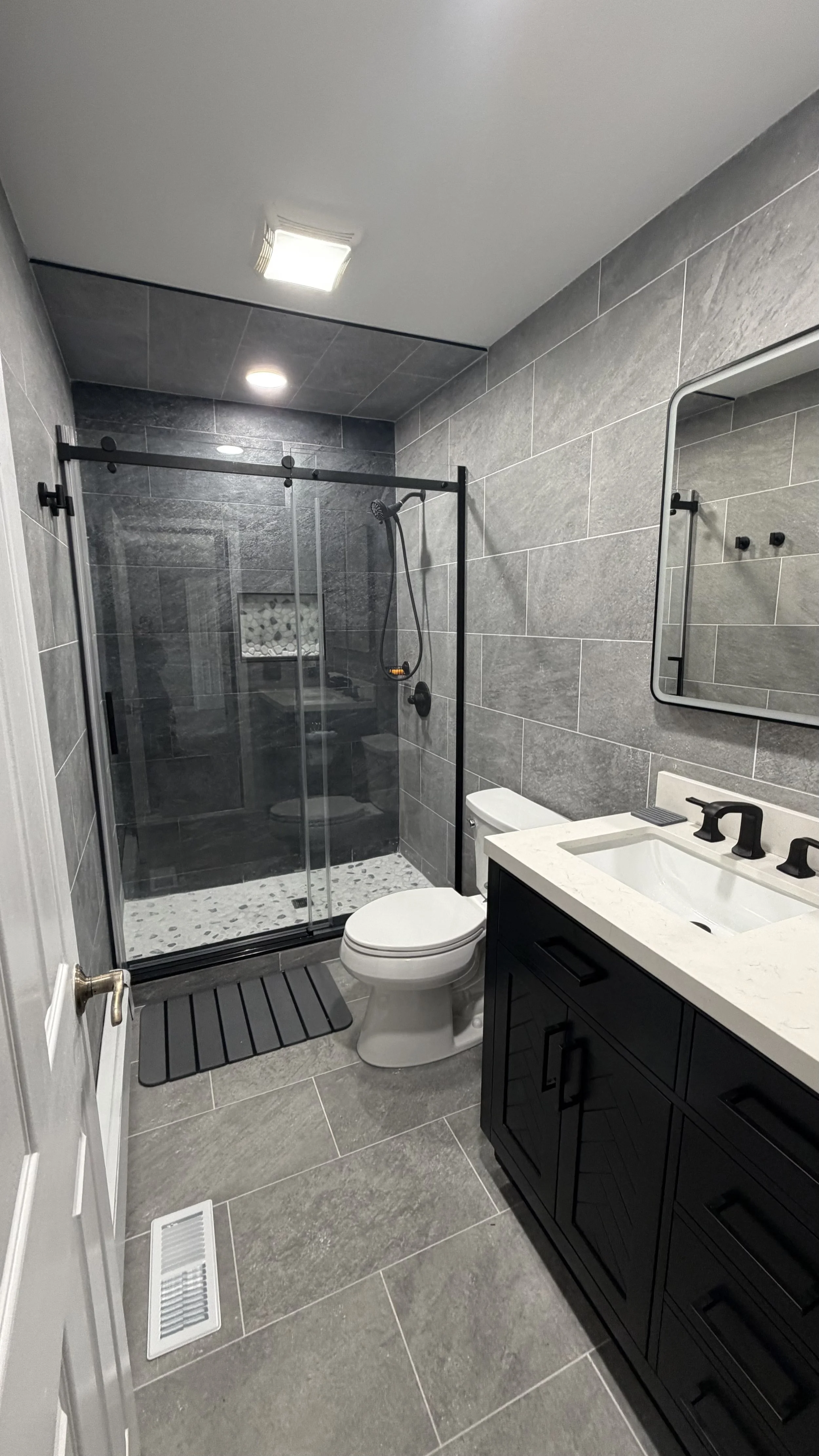 Demolition, tile flooring, wall, light fixture, shower fixtures and door installation.