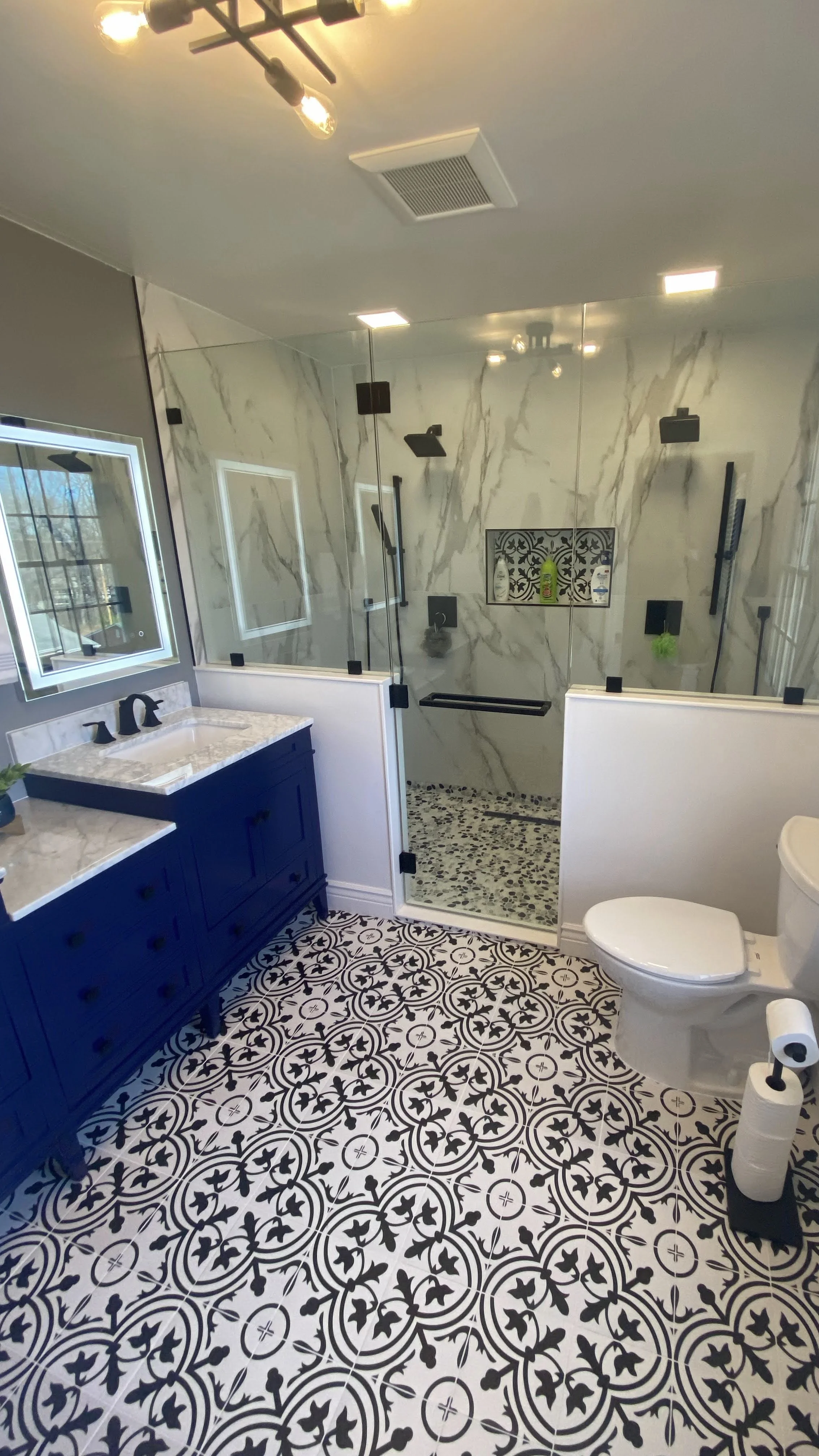 Demolition, tile flooring, wall, light fixture, shower fixtures, toilet, vanity and door installation.