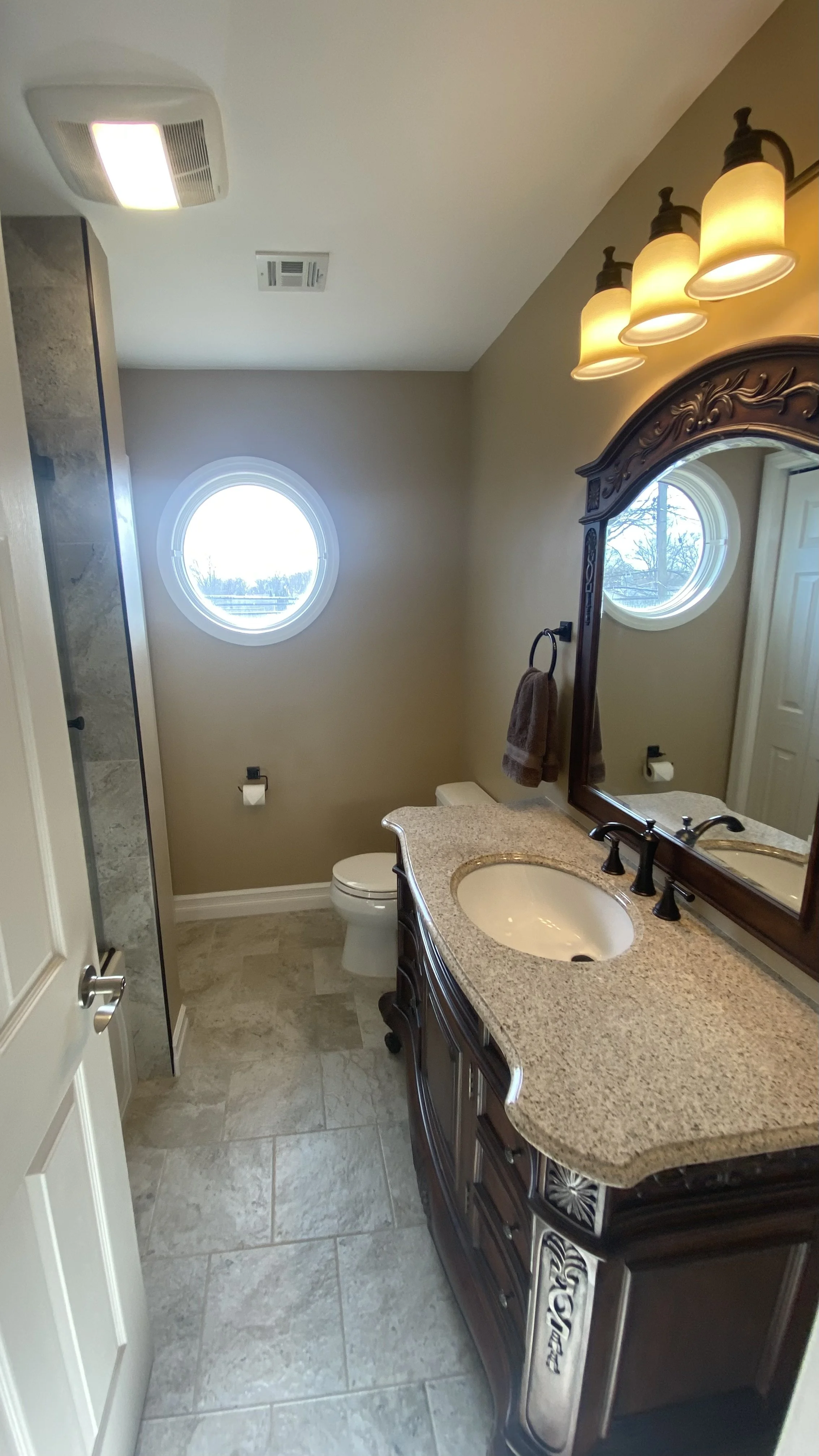 Demolition, tile flooring, wall, light fixture, shower fixtures, toilet, vanity and door installation.