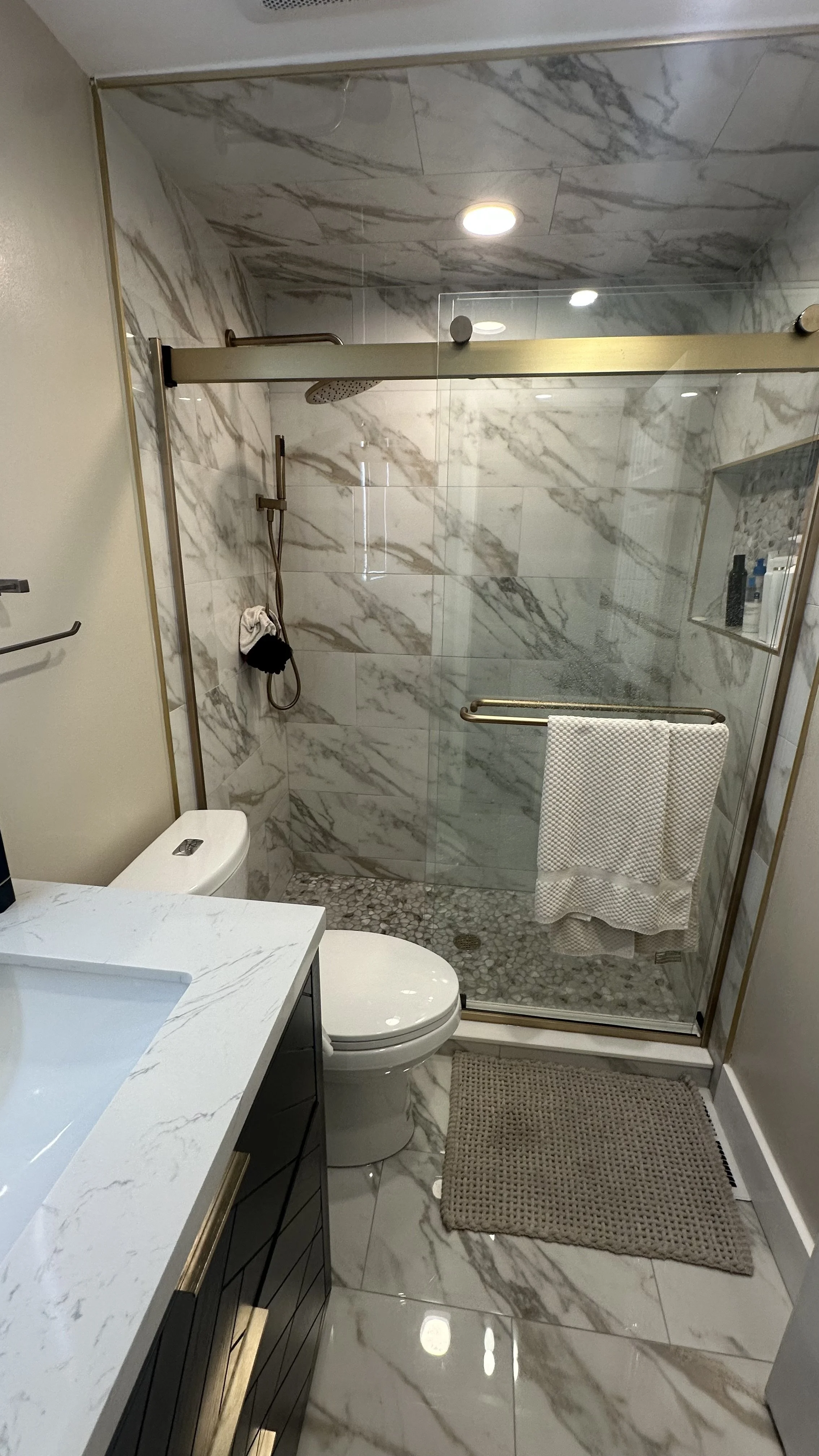 Demolition, tile flooring, wall, light fixture, shower fixtures, toilet, vanity and door installation.