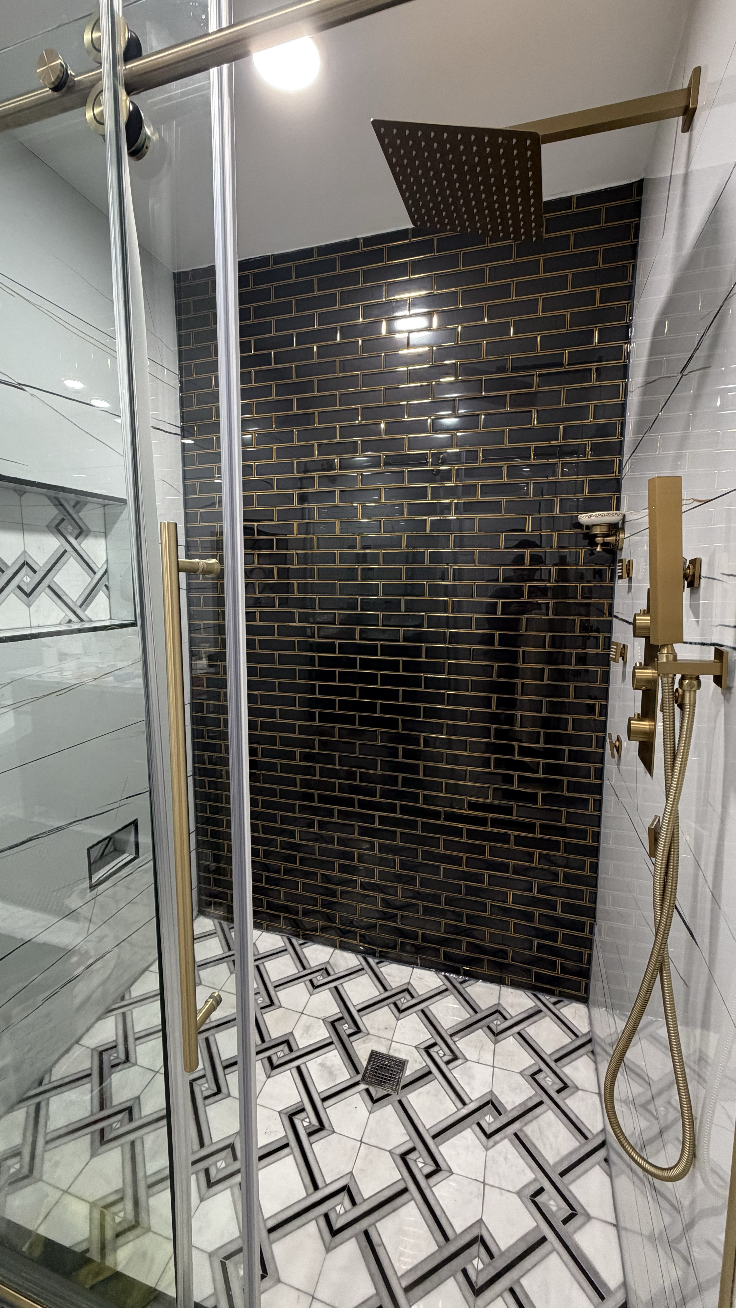 Demolition, tile flooring, wall, light fixture, shower fixtures and door installation.