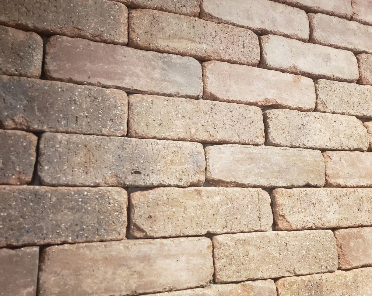 Close-up of a brick wall with light brown and reddish bricks.