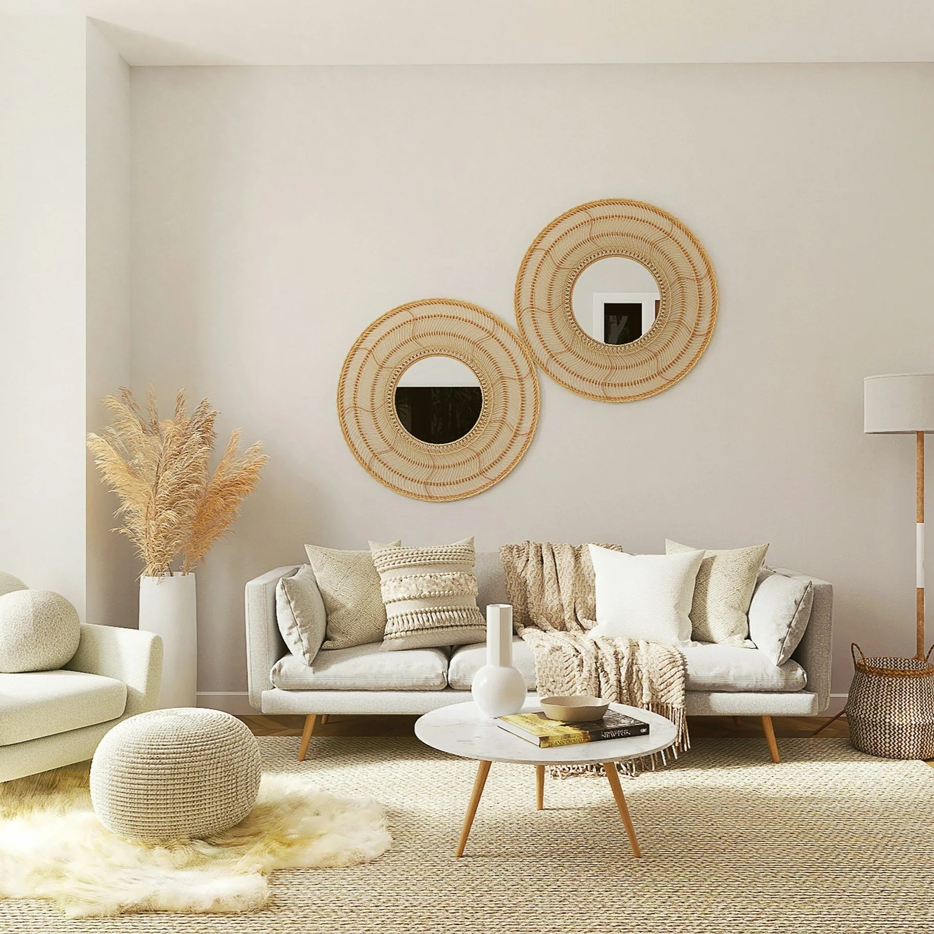 Modern living room with neutral tones, beige sofa with pillows, a round coffee table with decor, woven wall mirrors, pampas grass in a tall planter, and a floor lamp.