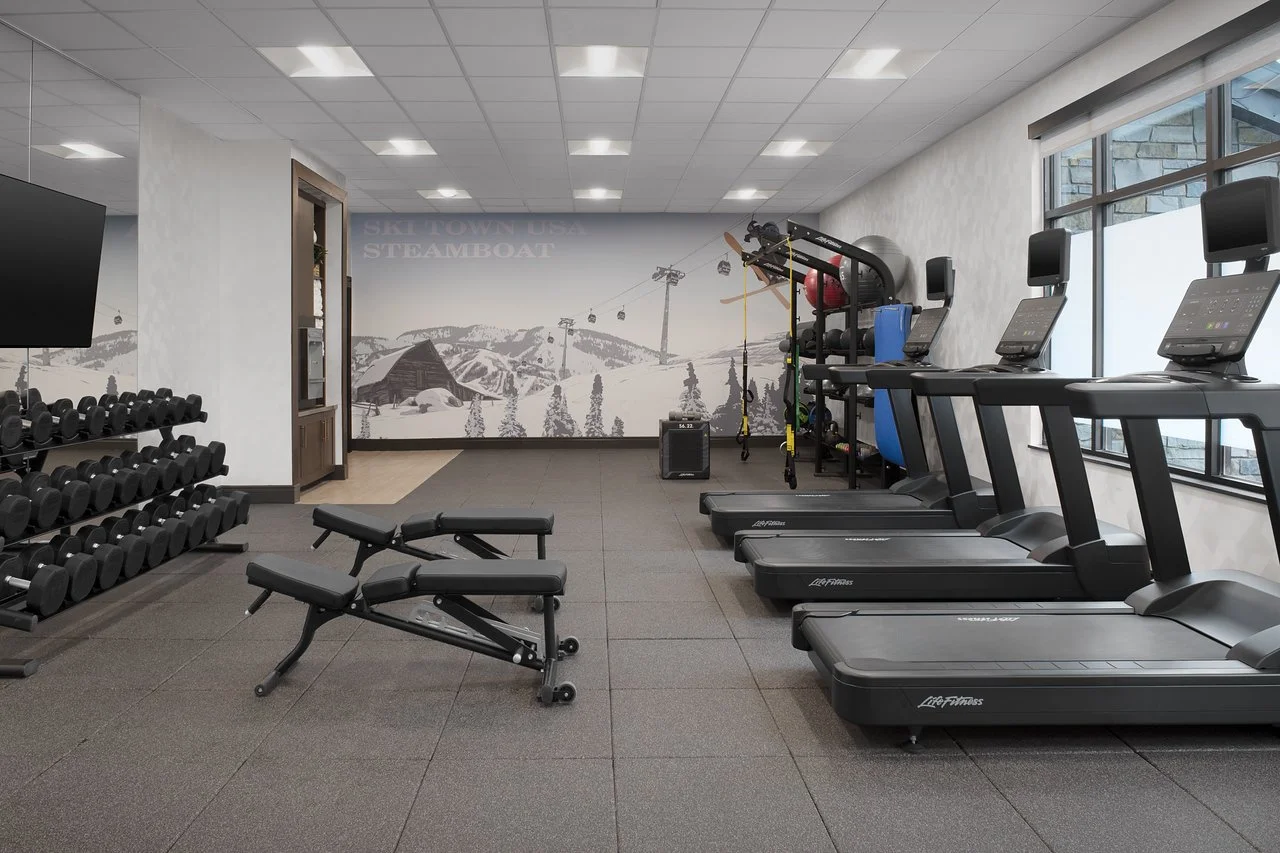 Blurry image of a fitness center with treadmills and gym equipment.
