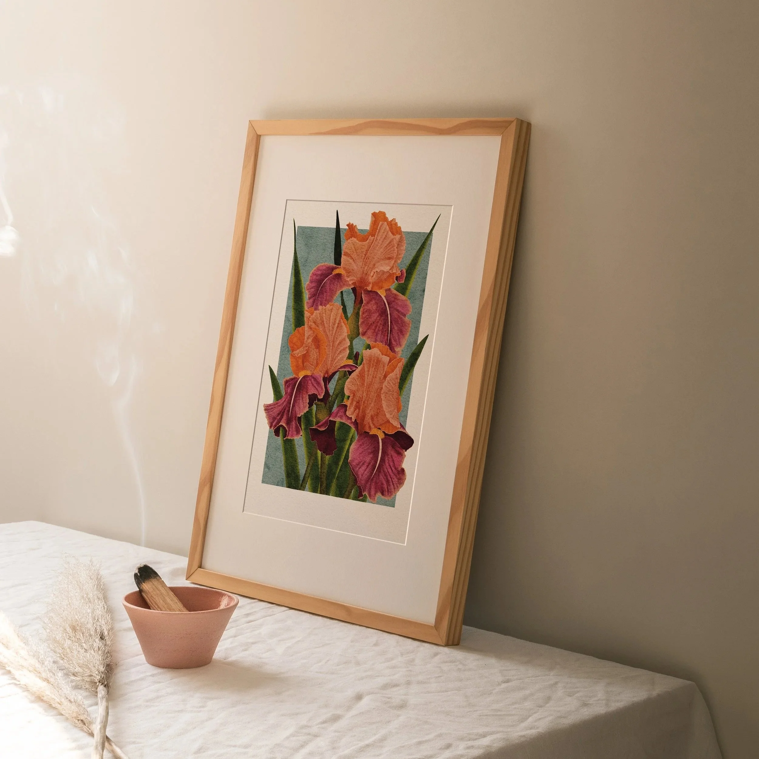 Carnaby Iris art print framed in light wood, propped against a wall with soft morning light and ceramic bowl, botanical wall art by Liz Govier Art Studio.