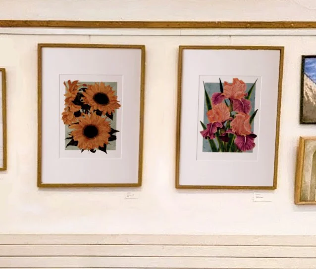 Framed A2 Sunflowers and Carnaby Iris prints hung side by side on an exhibition wall.