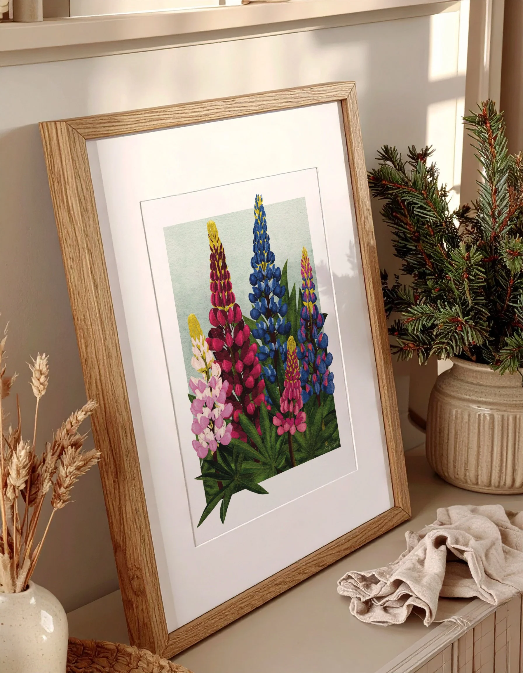 Framed Lupins fine art print styled with greenery and soft natural light, adding colour to a calm winter space.