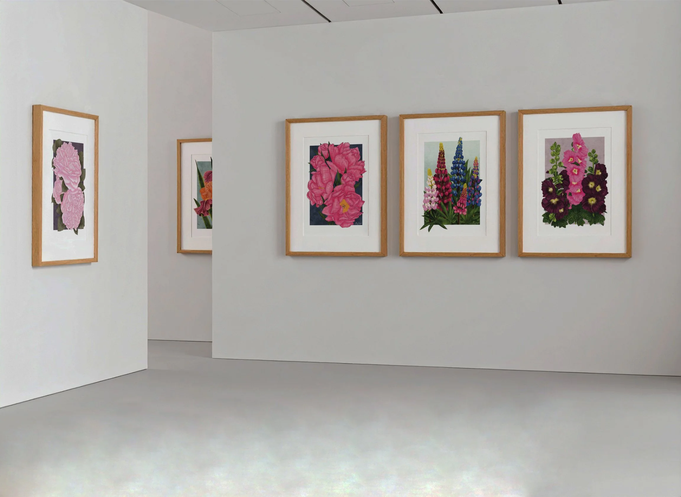 A gallery wall featuring framed botanical art prints by Liz Govier Studio — Pink Roses, Carnaby Iris, Lupins, and Hollyhocks — in oak frames.