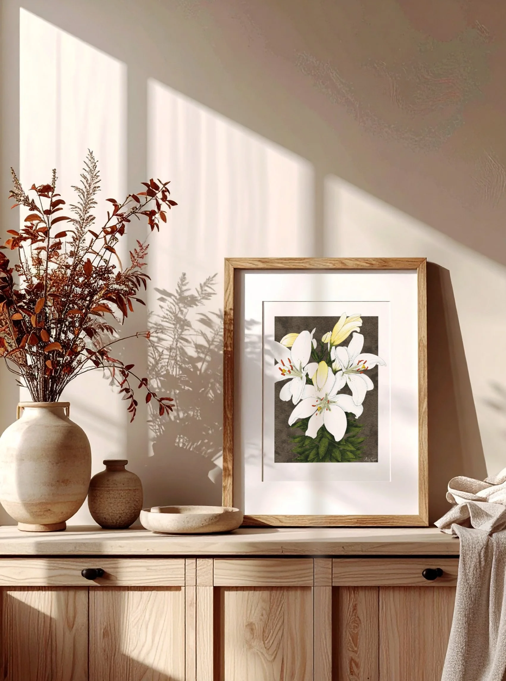 White Lilies fine art print by Liz Govier Studio on a sideboard in warm afternoon light, styled with ceramic vases and neutral fabrics.