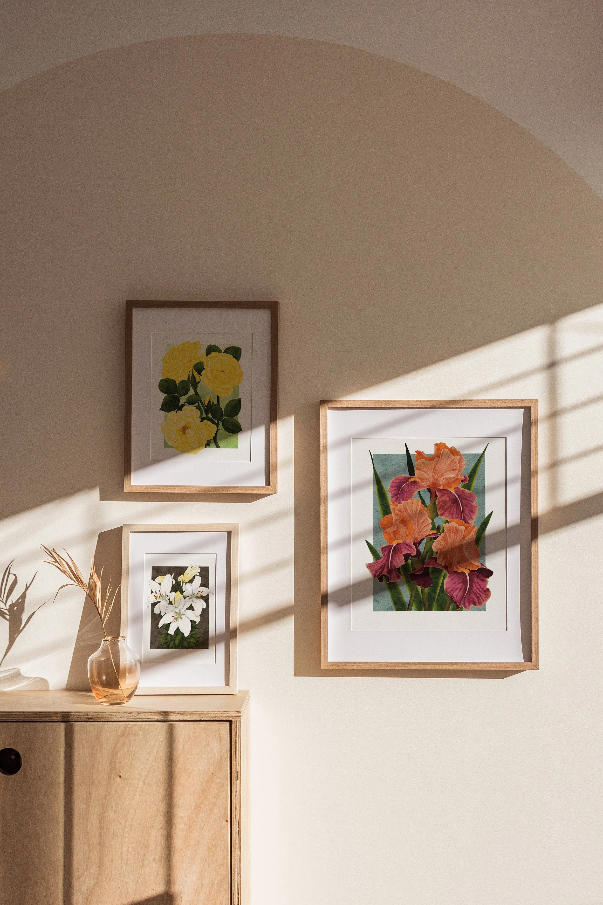 A softly lit wall displaying framed botanical fine art prints from The Botanical Collection by Liz Govier Art Studio.