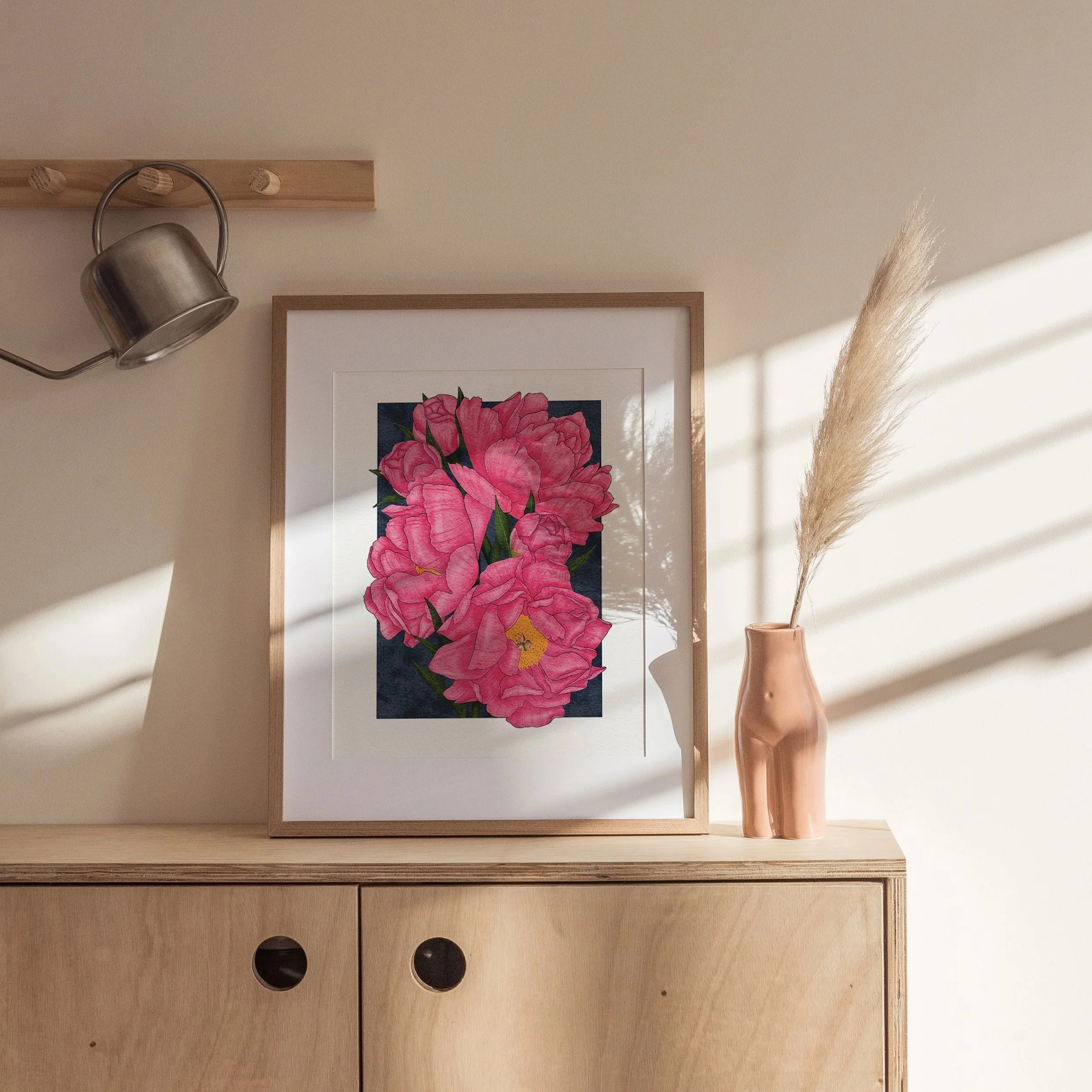 Framed Karl Rosenfield Peonies art print leaning on a cabinet with natural styling, bold pink botanical artwork by Liz Govier Art Studio.