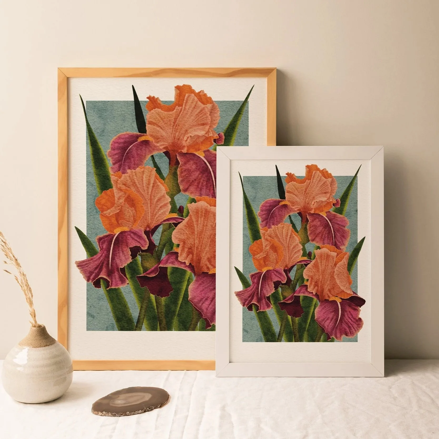 Pair of Carnaby Iris art prints framed in white and light wood, displayed on a linen-draped table with ceramic vase, botanical wall décor by Liz Govier Art Studio.