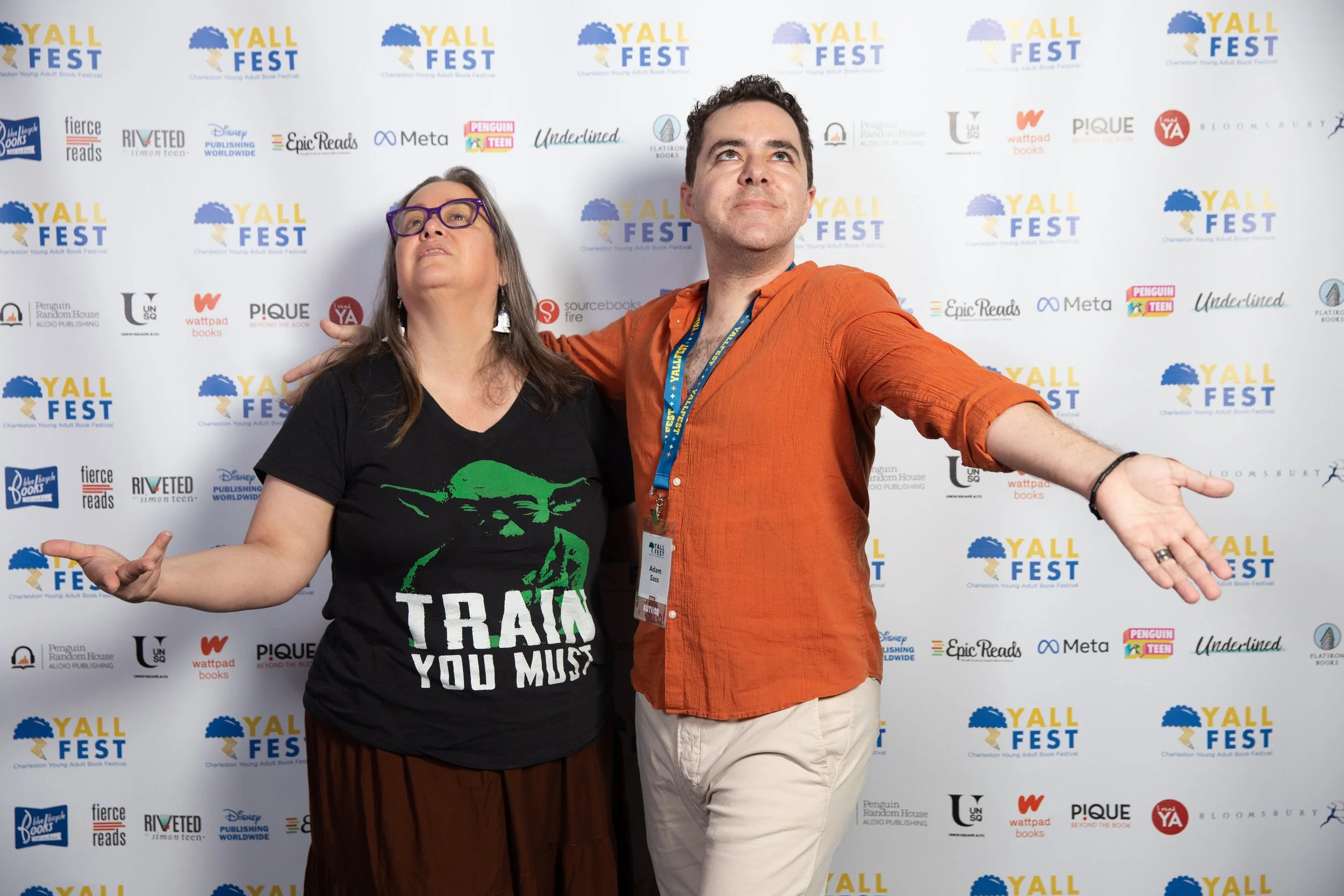 Authors Cynthia Leitich-Smith and Adam Sass pose in front of the step and repeat