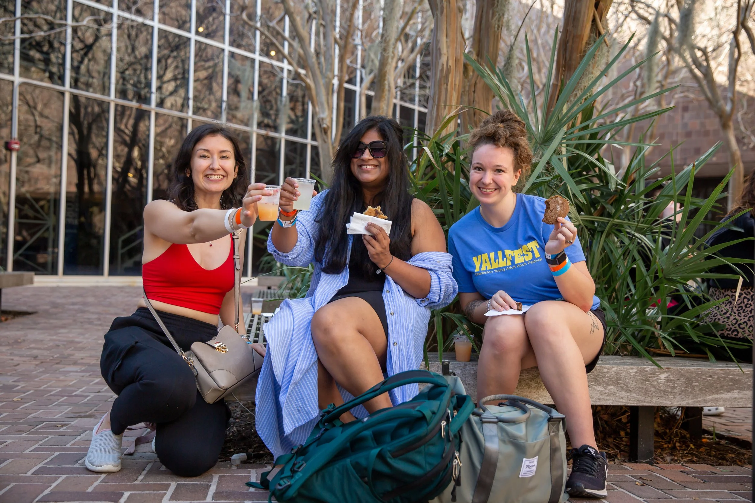 Three fans pose with food and bevvies