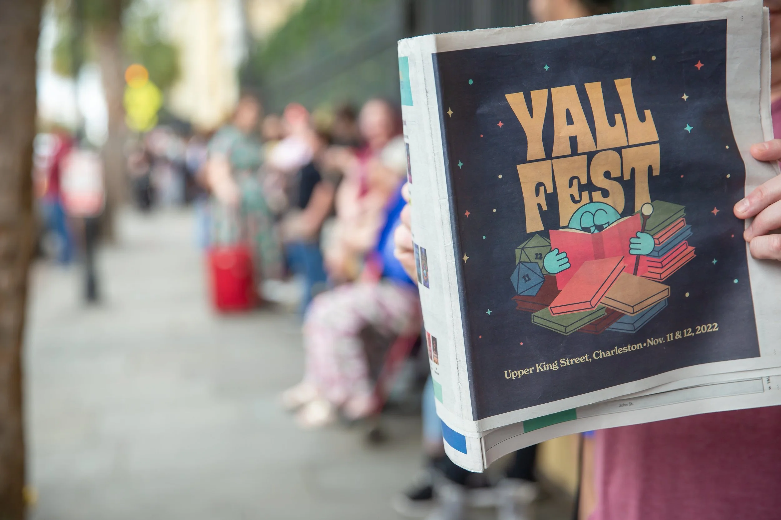 A fan holds up a YALLFest newspaper