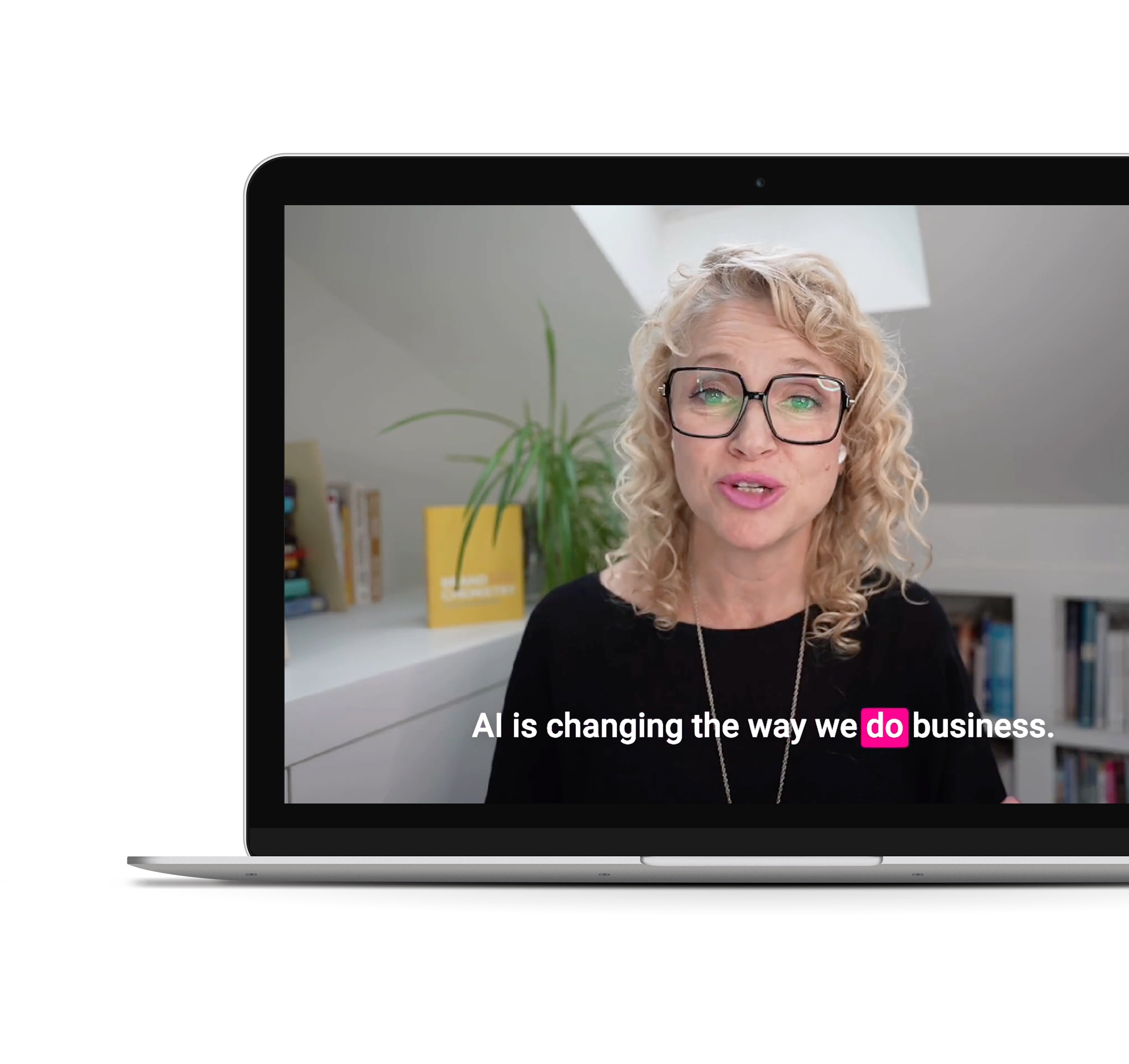 Laura Beauparlant wearing black frame glasses speaking on a laptop video call, with a bookshelf and a plant in the background. The caption reads 'AI is changing the way we do business'.