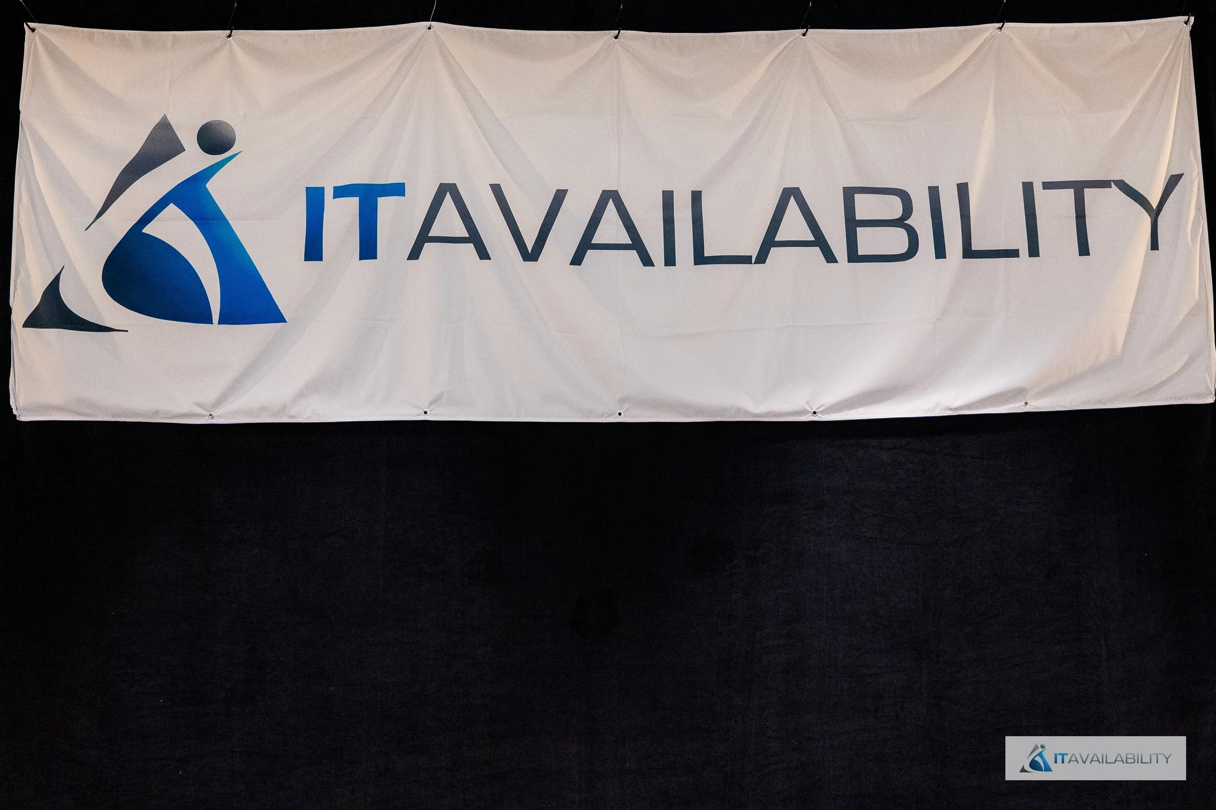 Large white banner with the logo of a stylized figure in shades of blue and gray, and the words 'IT AVAILABILITY' in bold blue and gray letters.