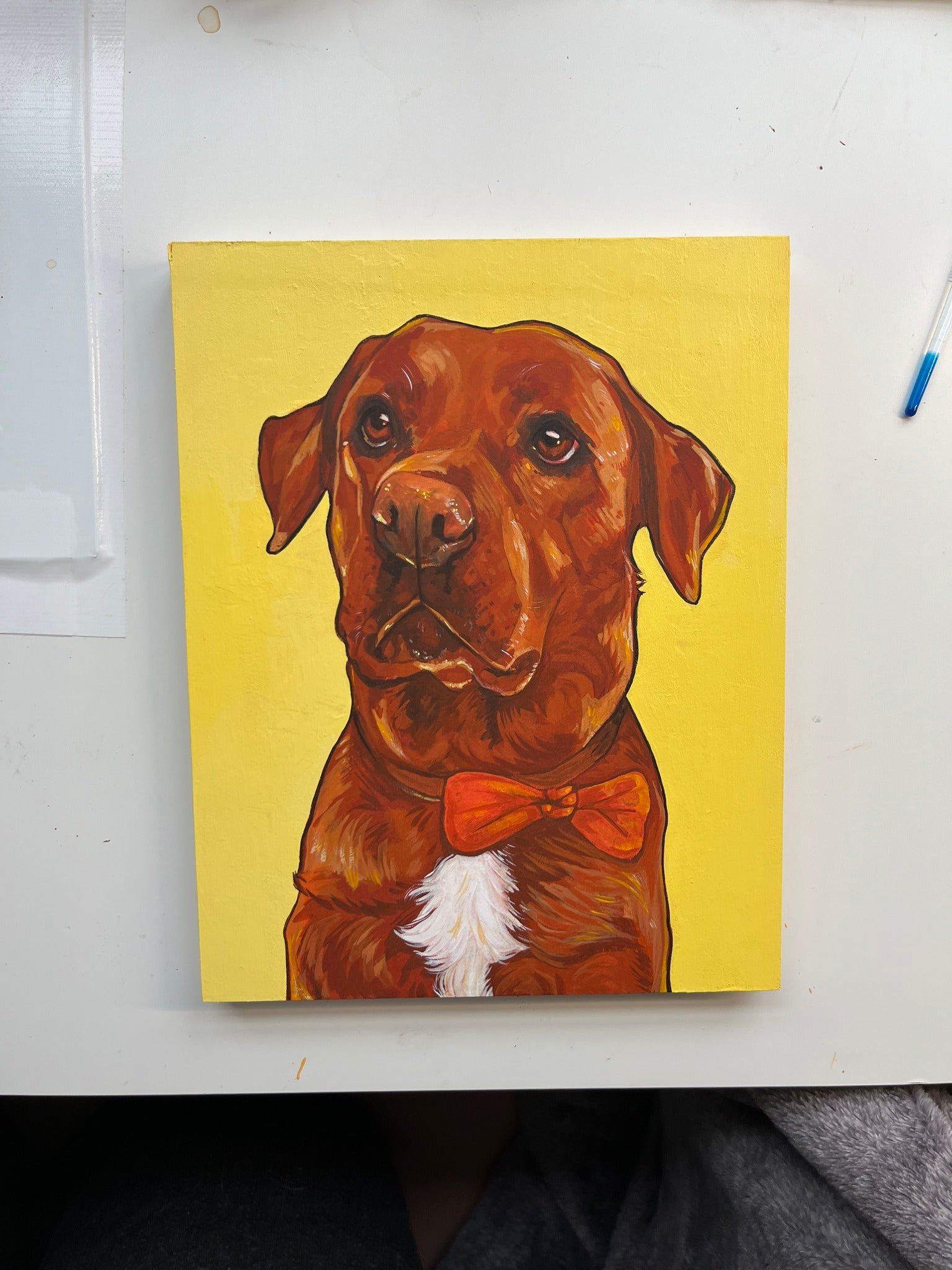 Painting of a brown dog wearing a red bow tie on a yellow background.