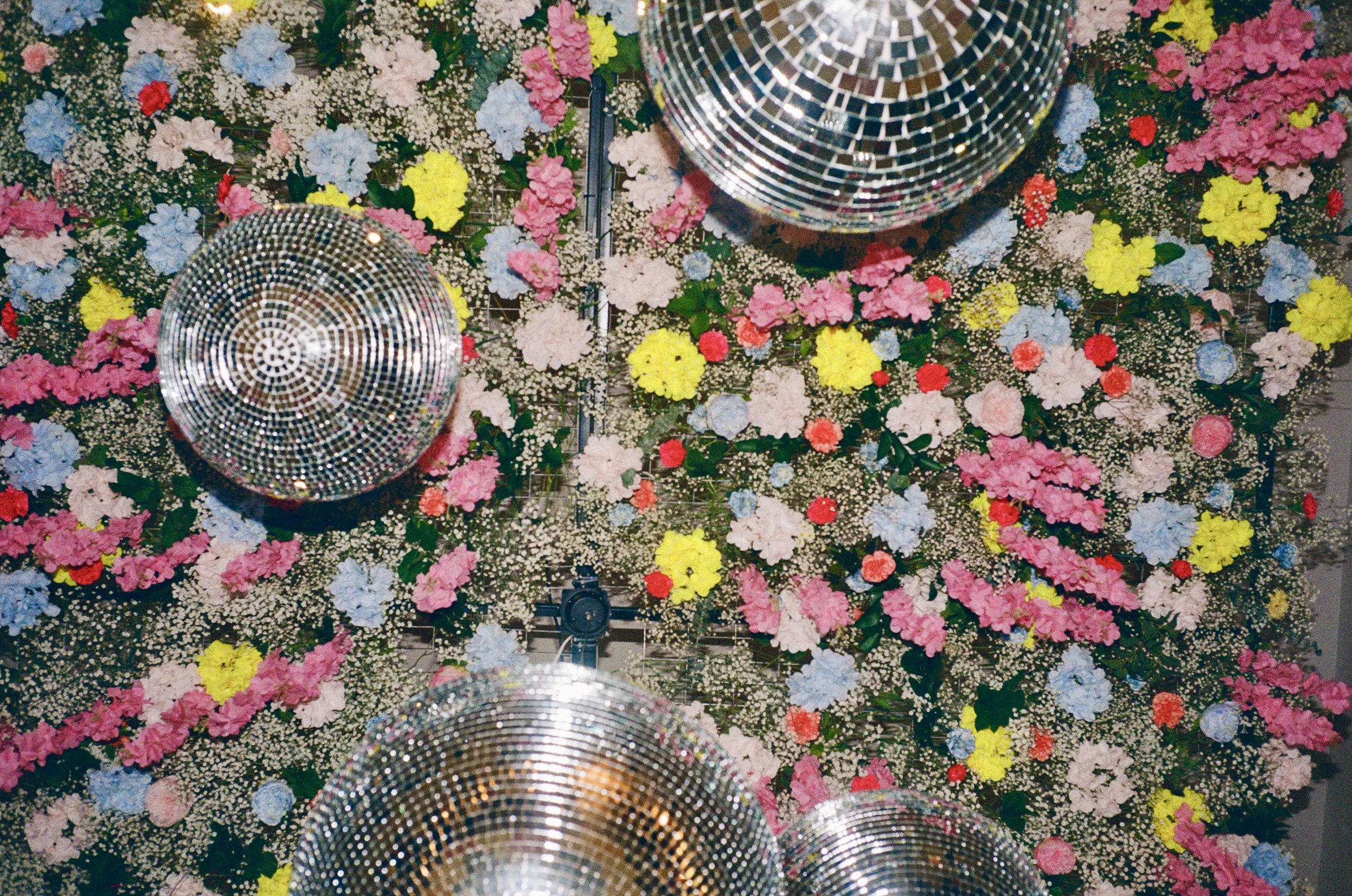 Ceiling decorated with colorful flowers and disco balls.