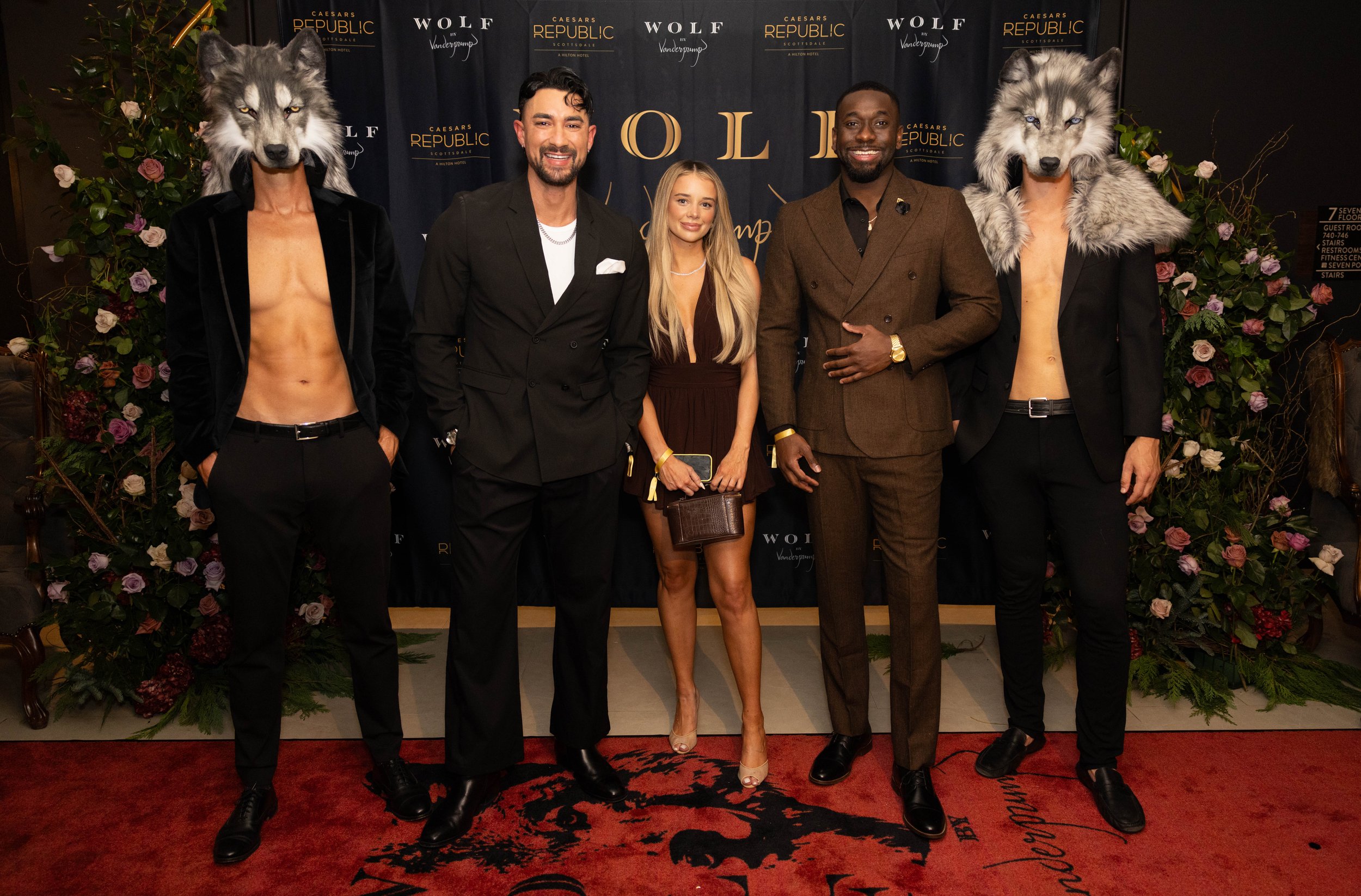 Cast of Vanderpump Villa posing on red carpet outside Wolf by Vanderpump Scottsdale.
