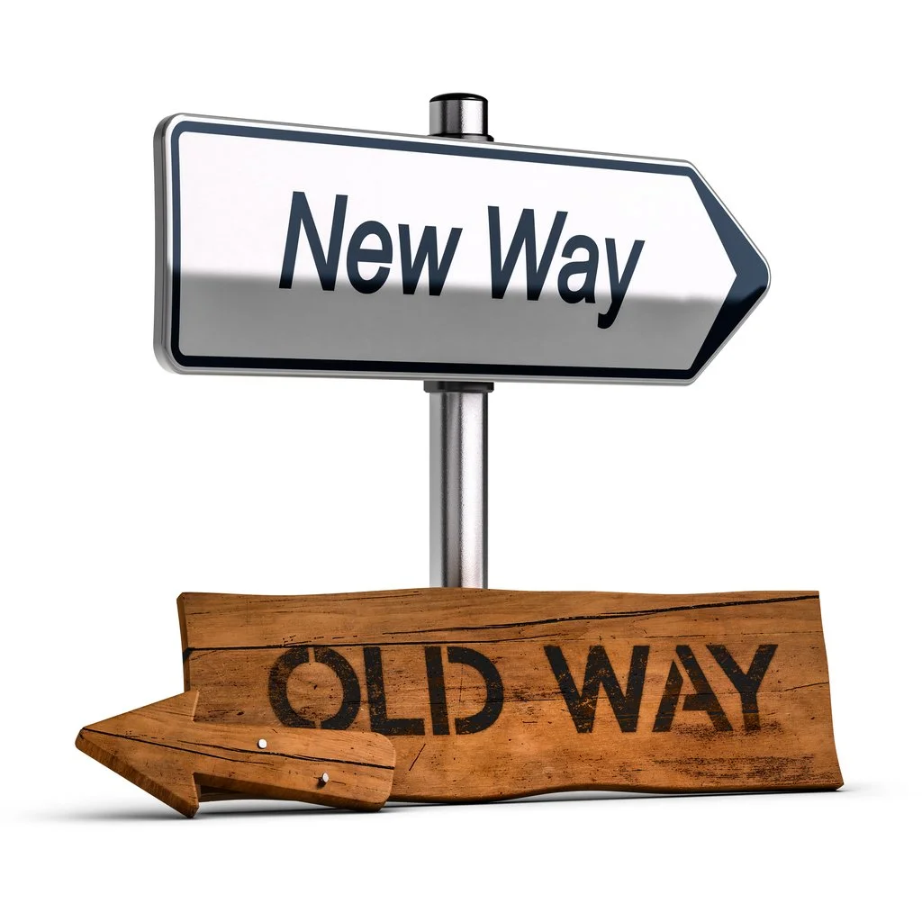 Signpost with an arrow pointing to the right labeled "New Way" and a wooden arrow on the ground pointing left labeled "Old Way."