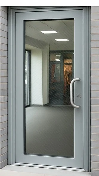 Glass door with silver handle leading to an indoor office space with ceiling lights and windows.