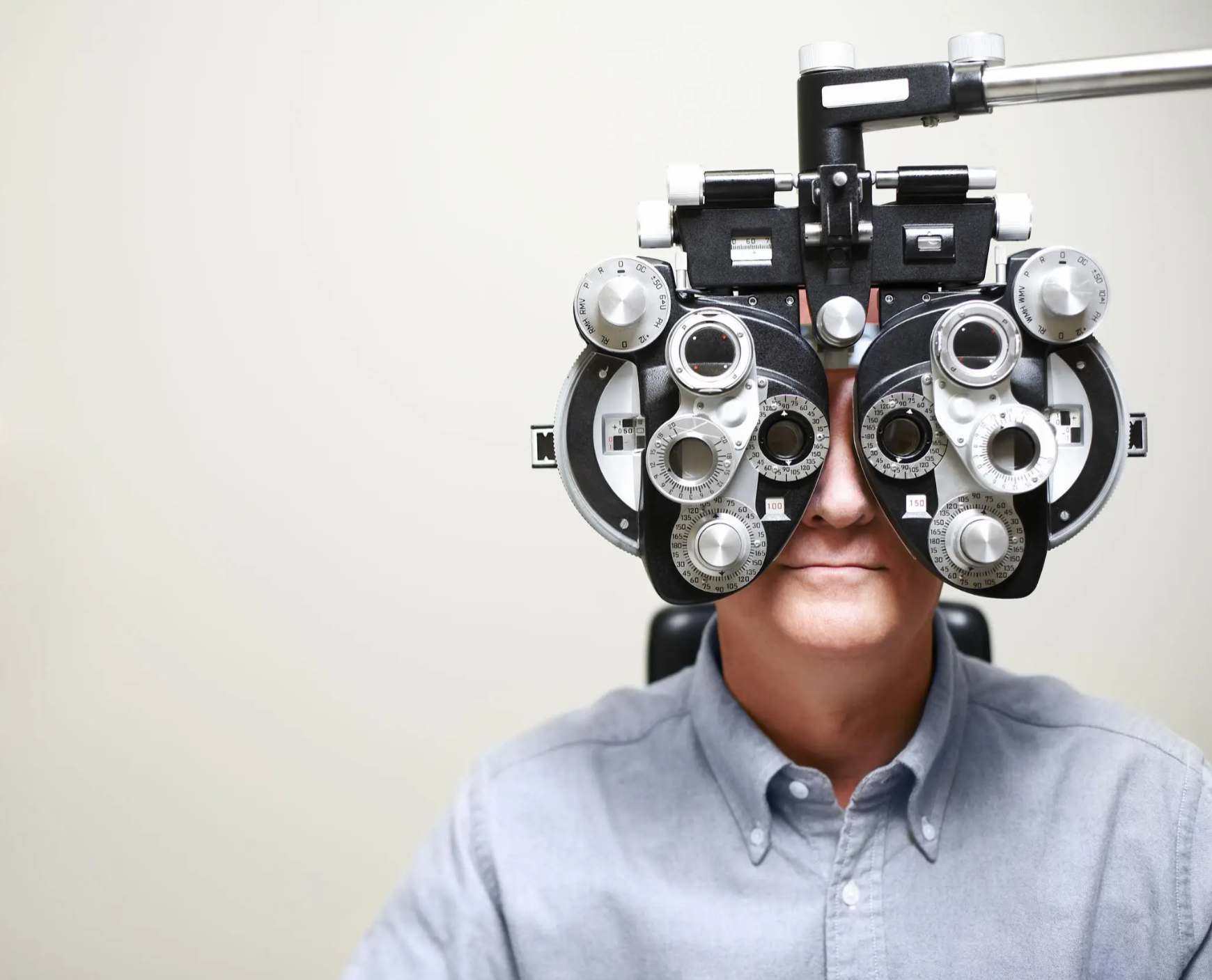 Person wearing a phoropter for eye examination.