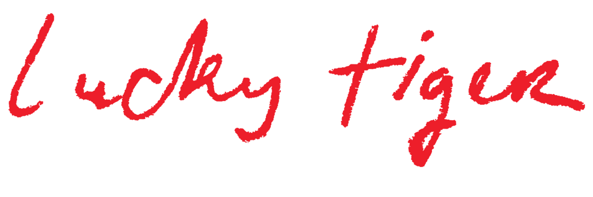 The phrase 'lucky tiger' written in red, cursive handwriting.
