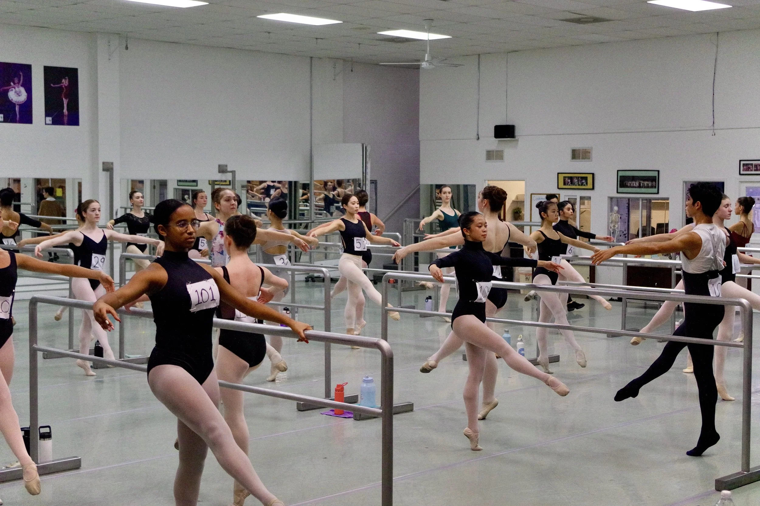 Ballet students practicing at ballet barre in a dance studio