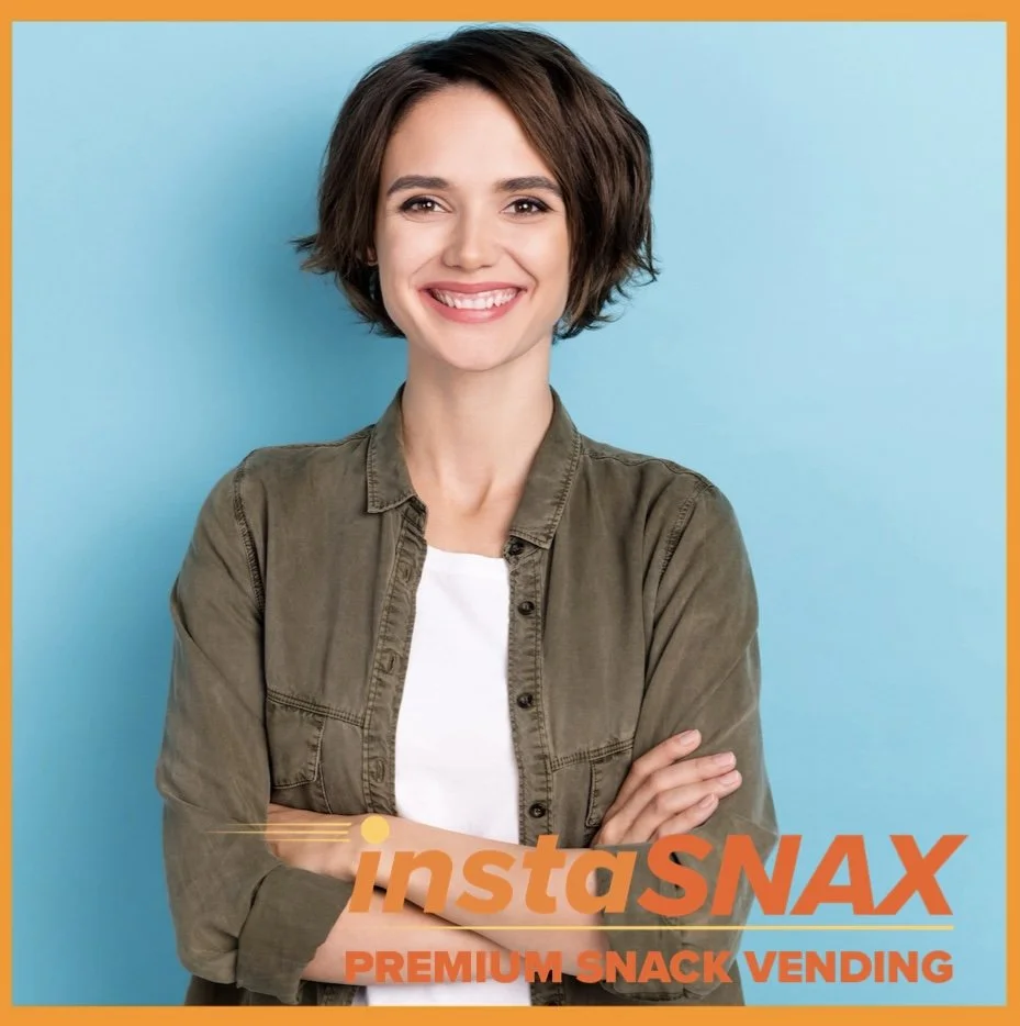 Millenial woman with a bob haircut and crossed arms smiles at the camera, text below reads ‘instaSNAX premium snack vending’