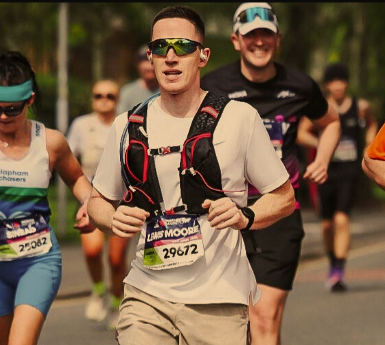 A group of marathon runners participating in a race outdoors, with trees and other runners in the background.