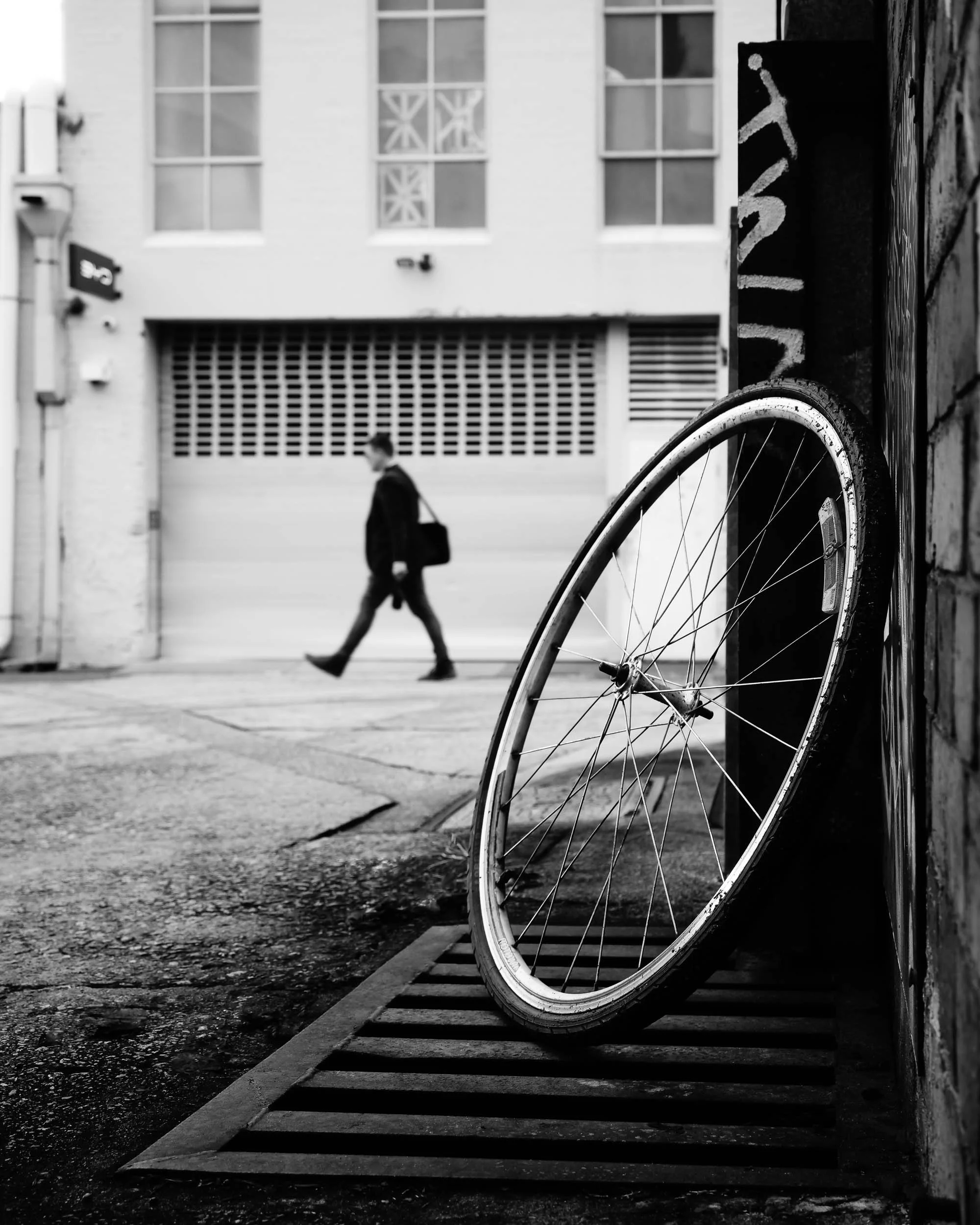 Paused Moments, Moving Lives: A solitary wheel elegantly rests, while life's purposeful rhythm profoundly continues. It's a poignant visual reminder that even in stillness, unseen journeys eternally unfold, each finding its own captivating path throu