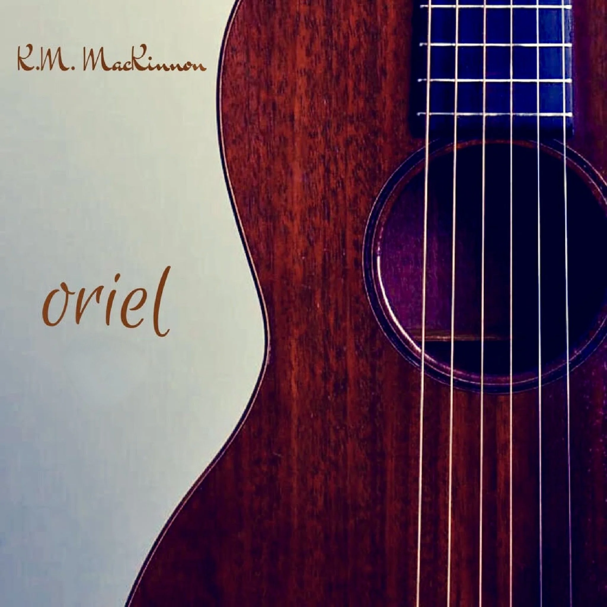 Cover of album titled 'ORIEL' by K.M. MacKinnon featuring a close-up of an acoustic guitar with a wooden top and strings.kmmackinnon.com guitarist and composer music available at YouTube, Spotify, Apple Music