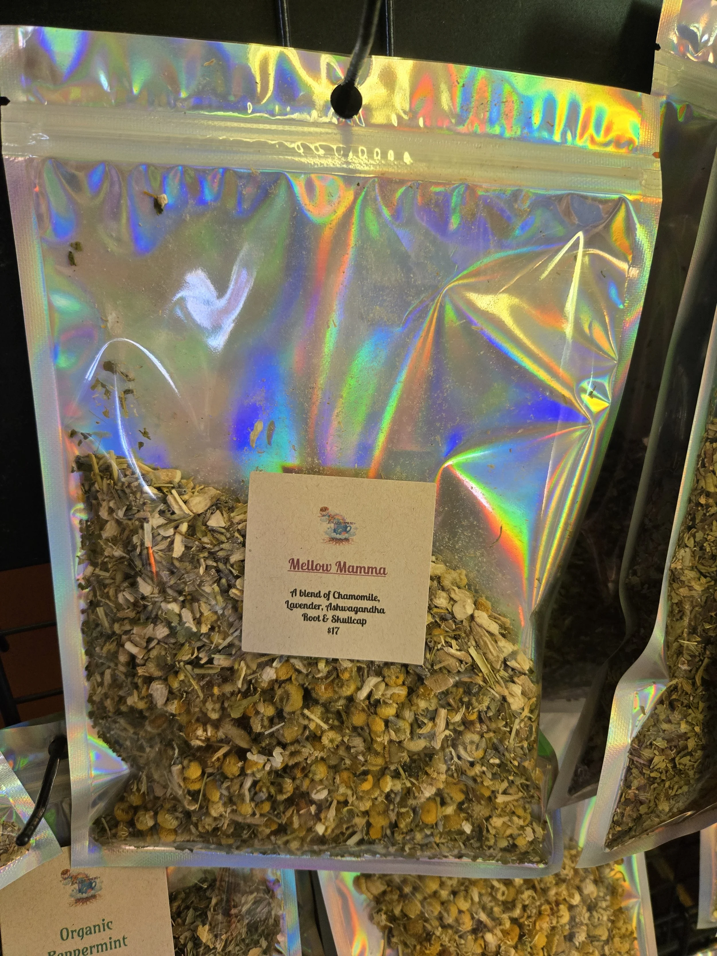Holographic plastic bag of herbal tea labeled 'Mellow Mamma', containing a blend of chamomile, lavender, Ashwagandha, root, and skullcap, priced at $17.