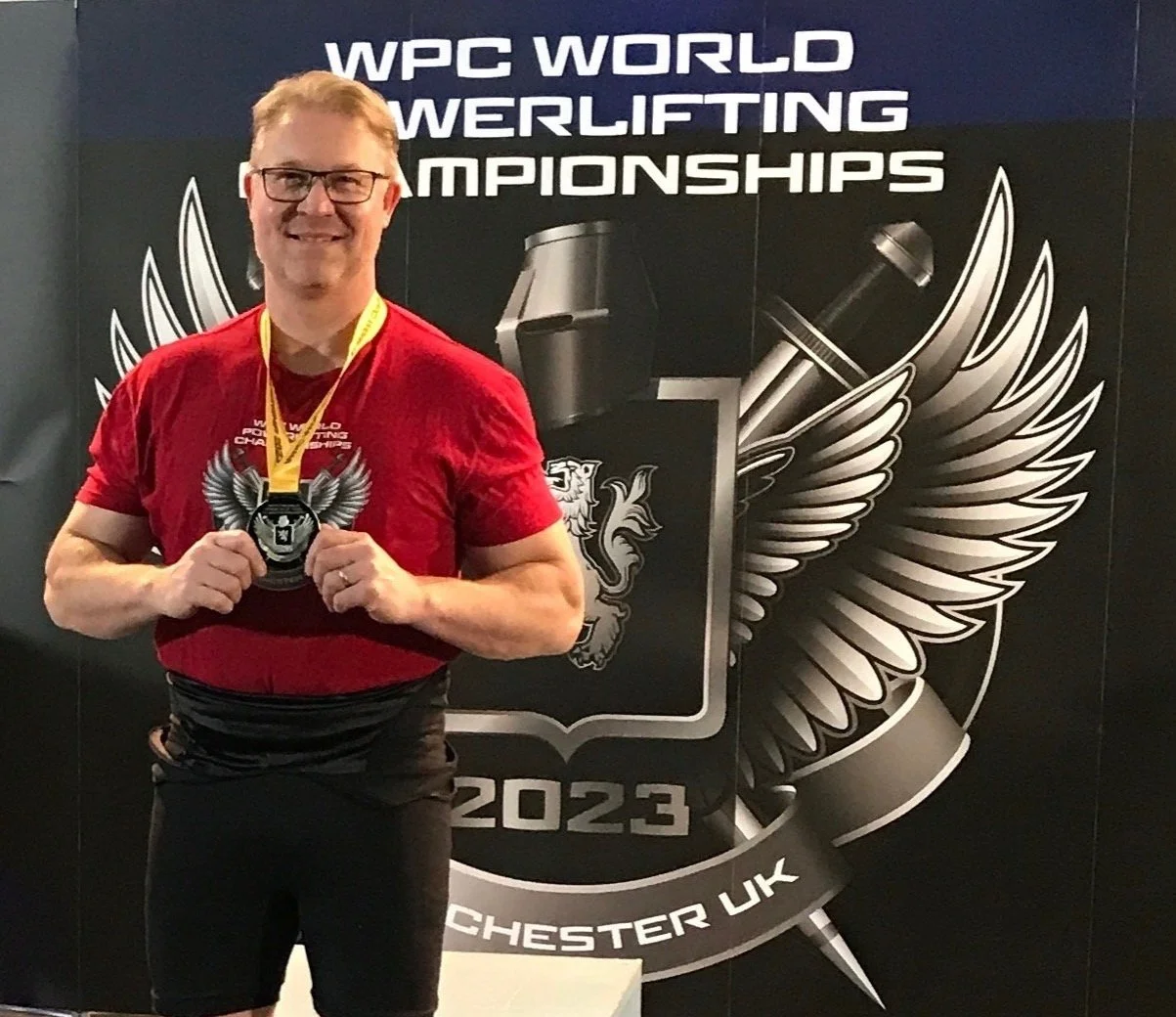 Nick Hill holding his metal at the WPC world powerlifting championship.