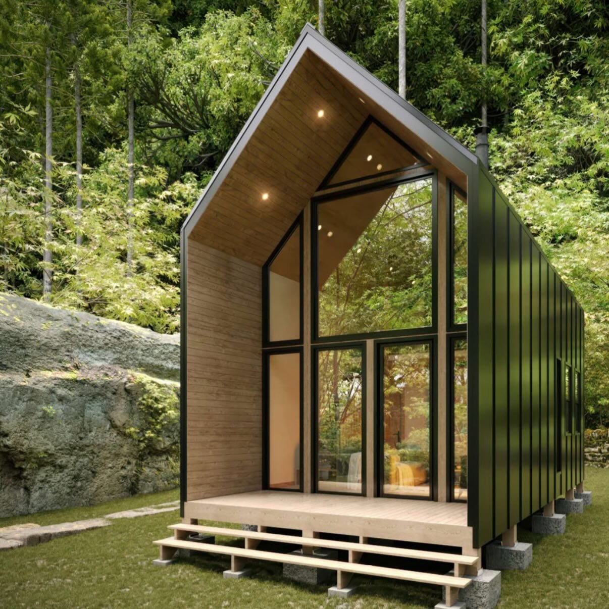 Modern tiny house with black exterior, large glass windows, and a wooden interior, situated in a green outdoor setting.