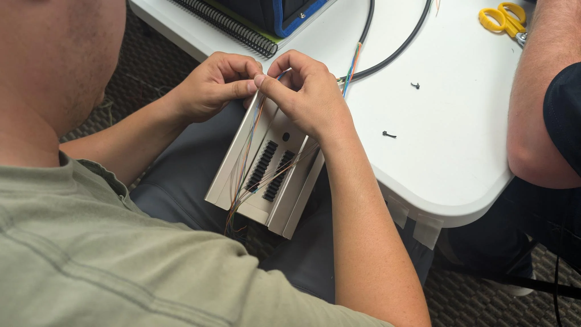 D&T Contractors trainee routing fibers into a splice tray during fiber optic training
