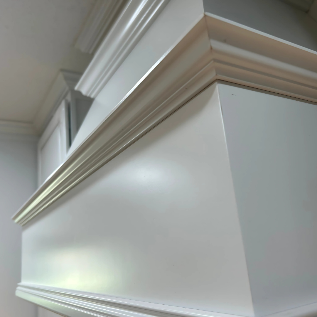 Close-up photo of decorative molding on a white piece of furniture or wall.