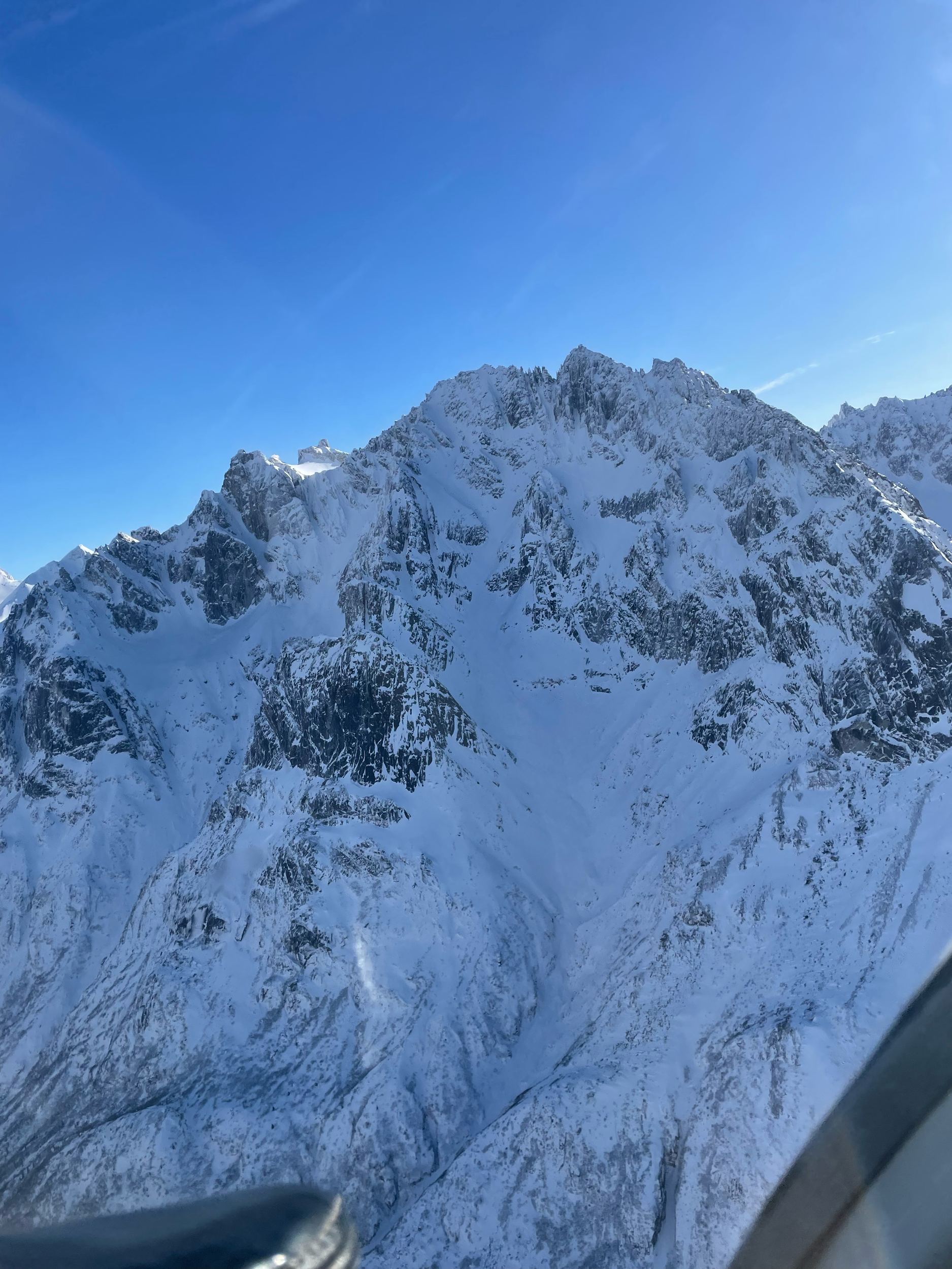 Snow-covered mountain range under a clear blue sky.