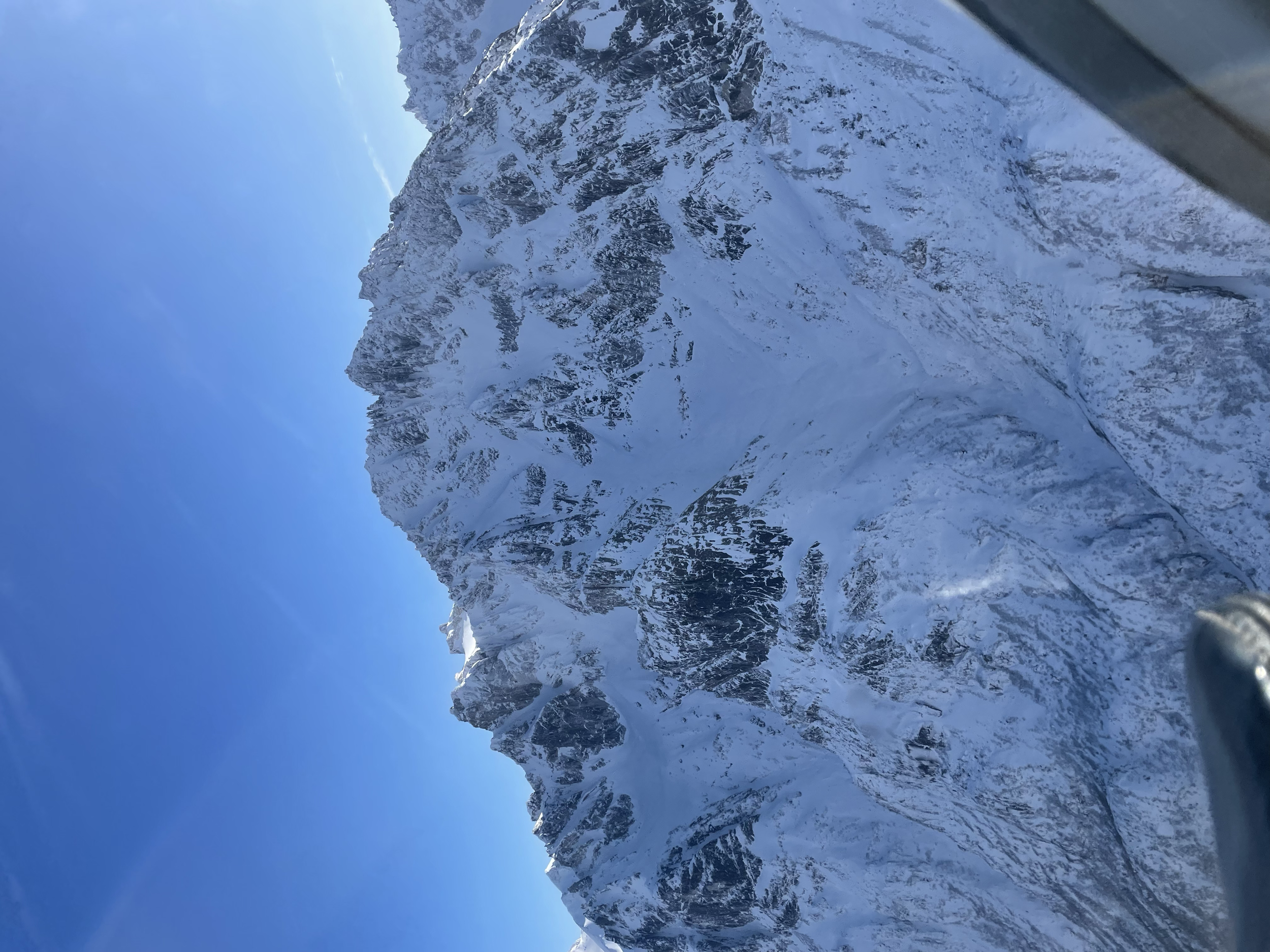 Snow-covered mountain range under a clear blue sky.