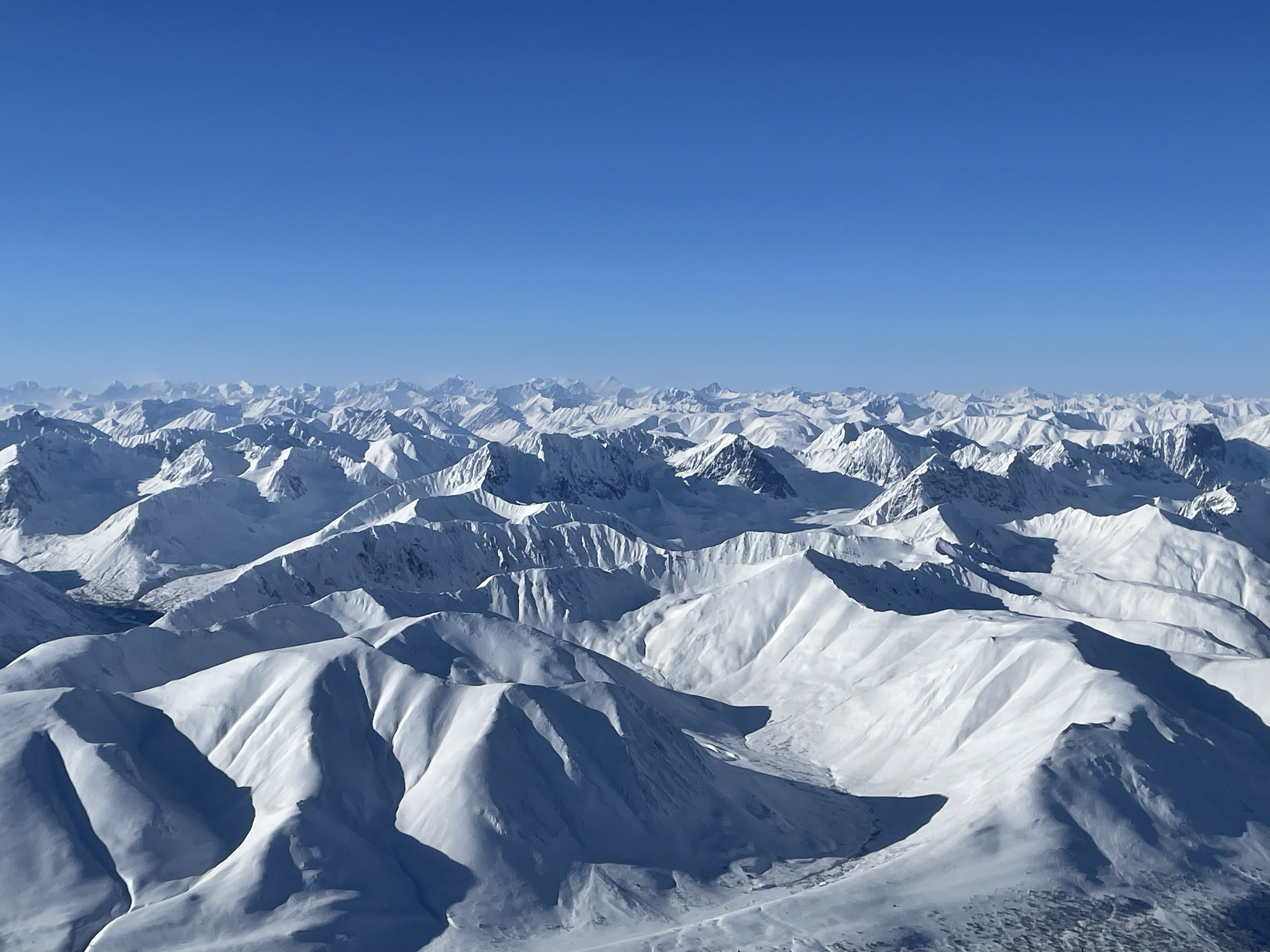 Snow-covered mountain range under a clear blue sky