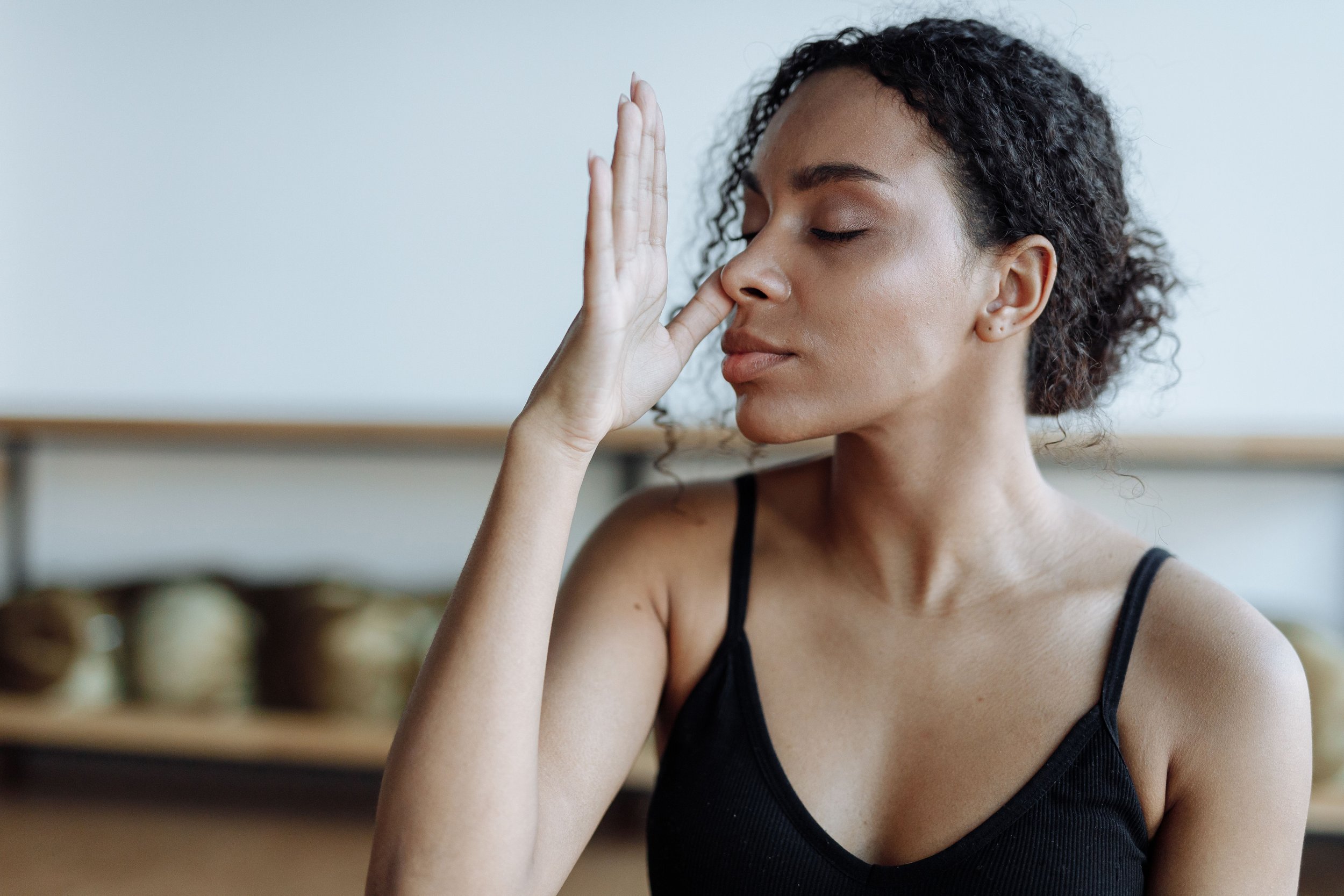 A woman seated with eyes closed in conscious breathwork practice, symbolizing the ancient and evidence-based connection between breath, nervous system regulation, and somatic healing