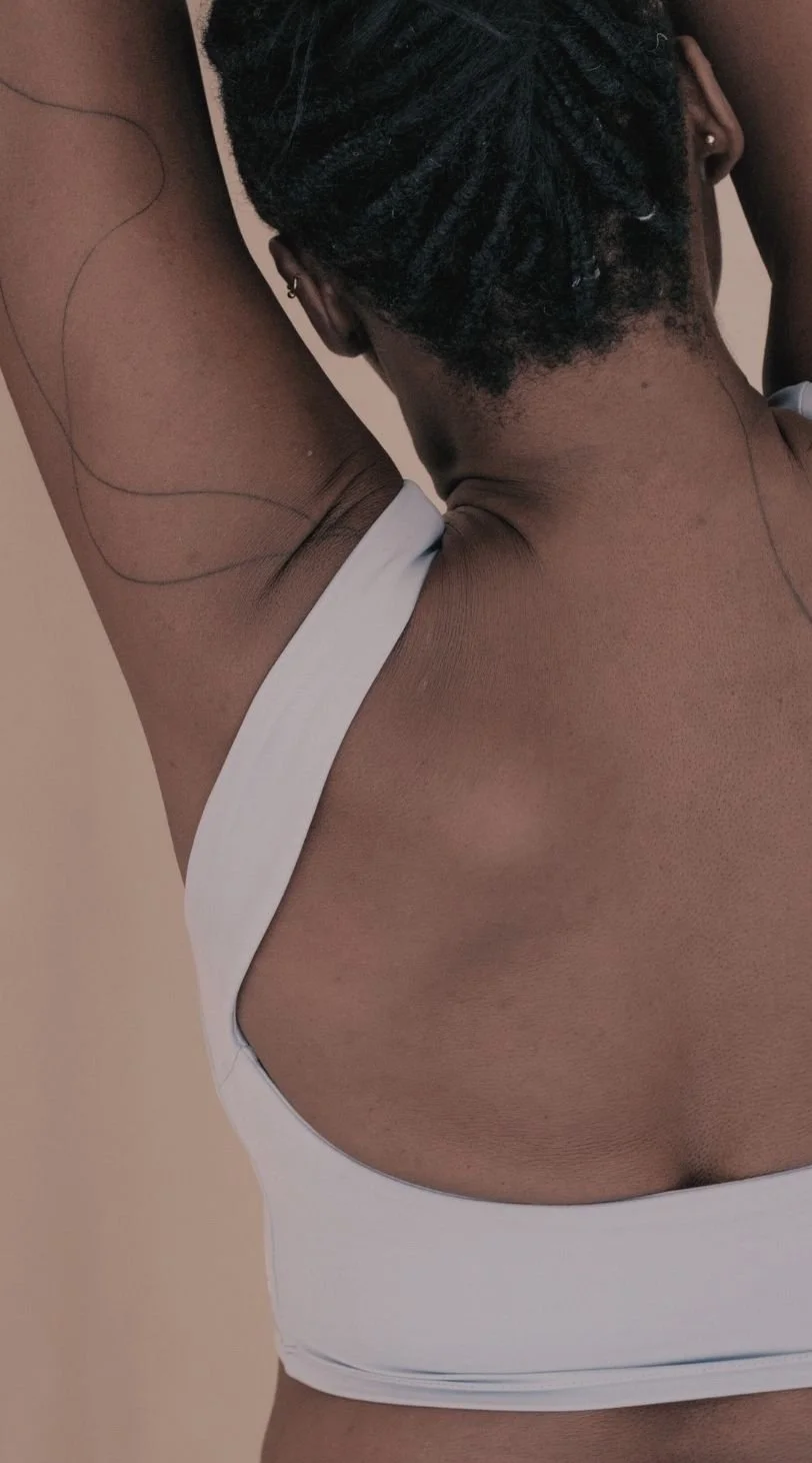 Close-up of a person with dark skin and short textured hair, arm raised in a natural, open posture, symbolizing embodiment, self-awareness, and the freedom to inhabit one’s body through Embodied Soul Psychotherapy™.